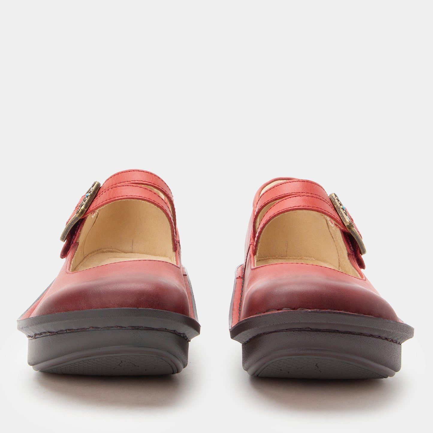 Pair of red shoes with a buckle on a white background