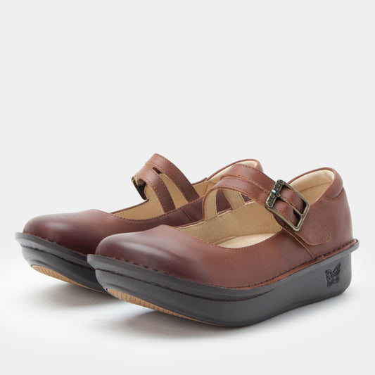 Pair of brown shoes with a strap and buckle on a white background