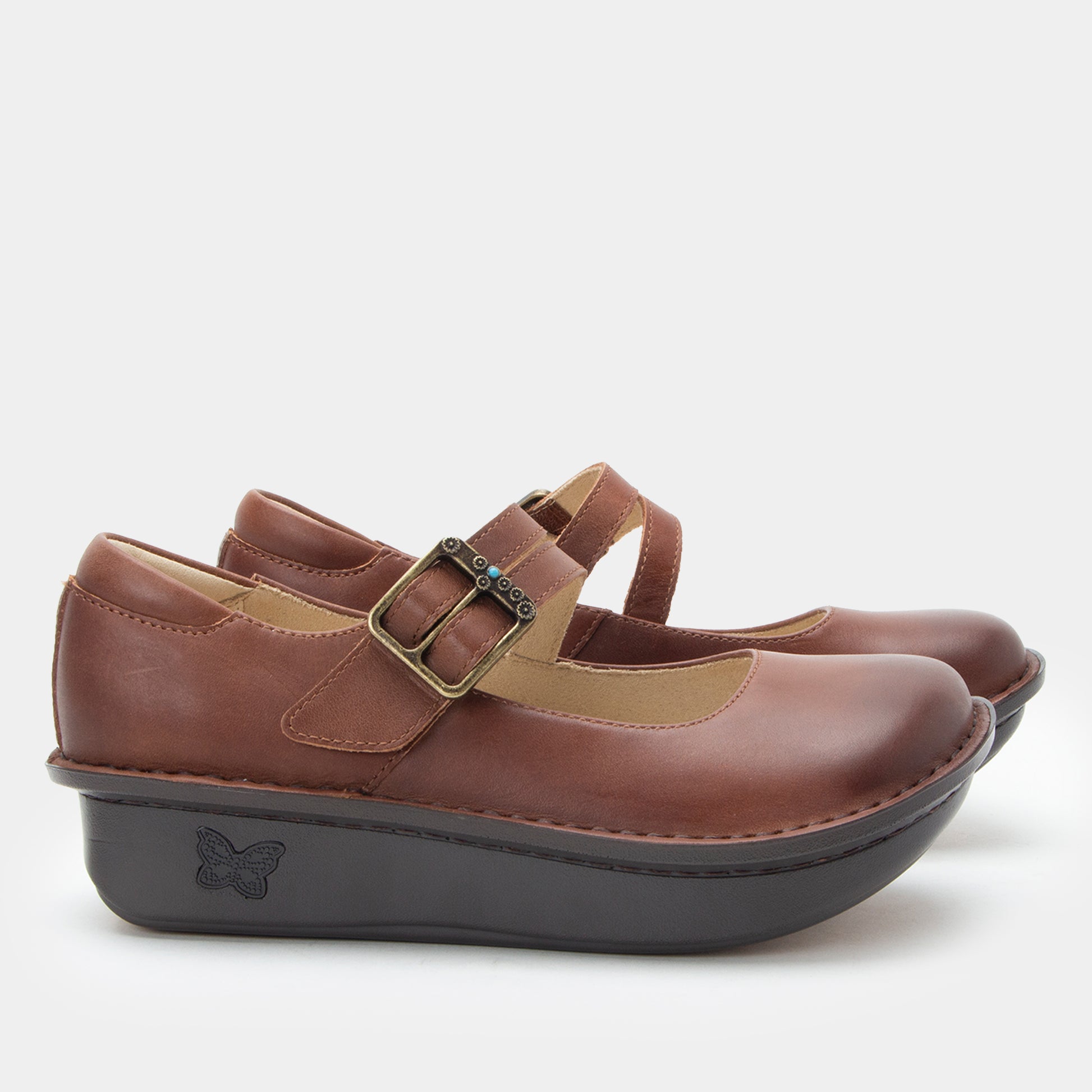 Brown shoes with a strap and black sole on a white background