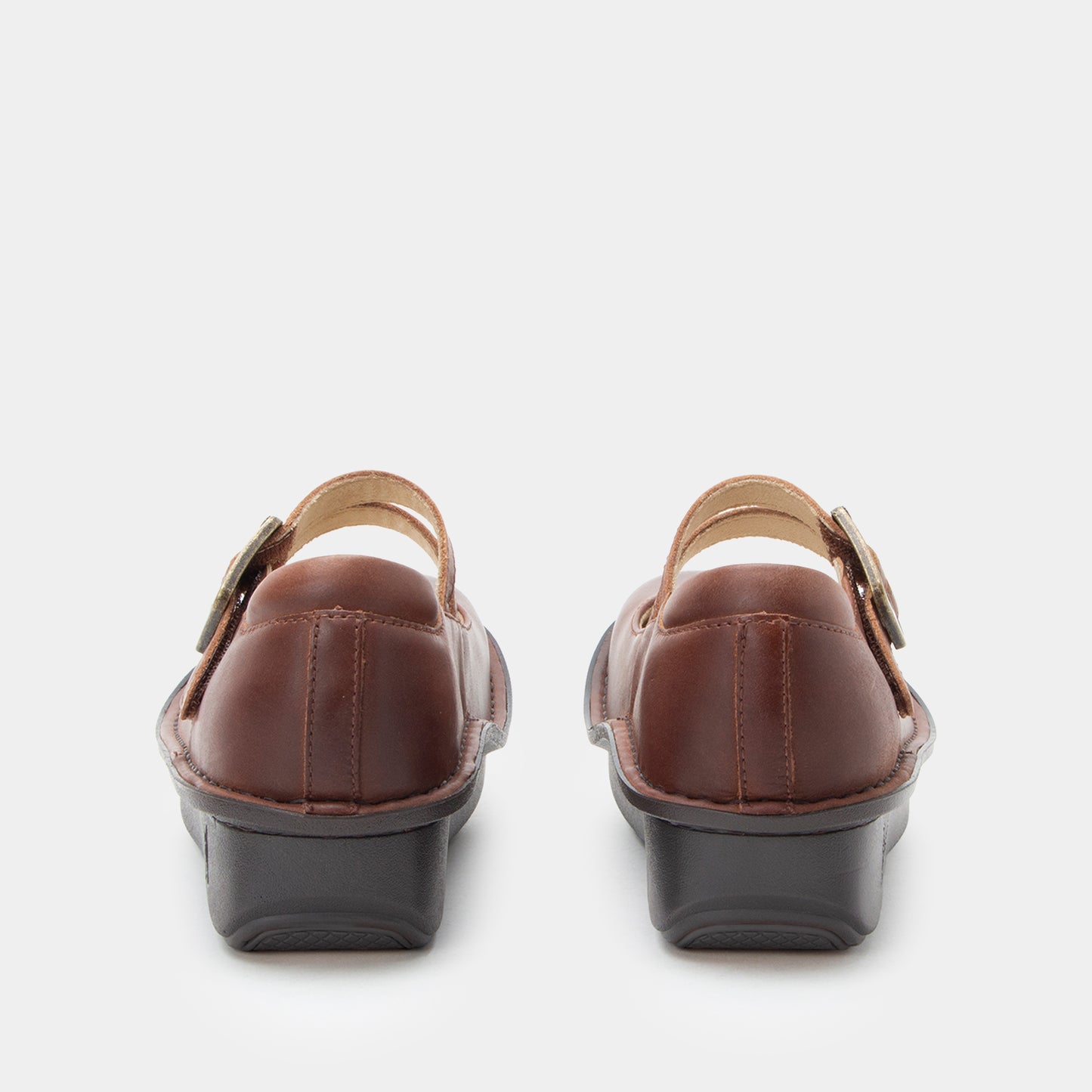 Pair of brown clogs with black soles on a white background