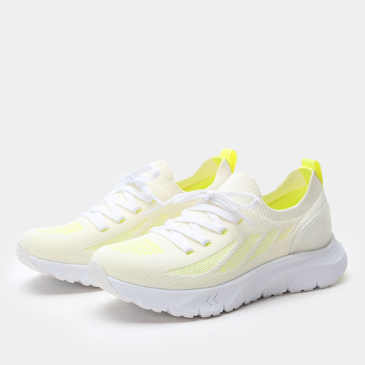 White running shoes with yellow accents on a light gray background