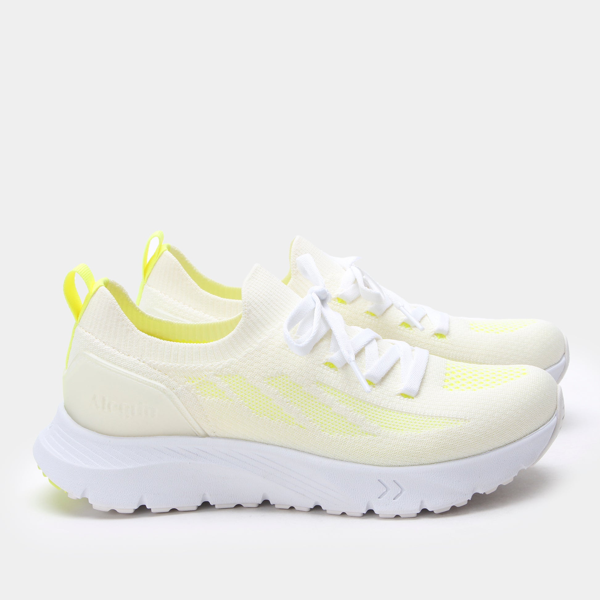 Light yellow sneakers with white soles on a light gray background