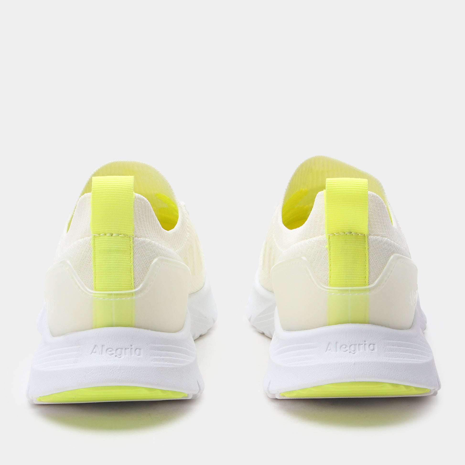 White running shoes with yellow accents on a white background