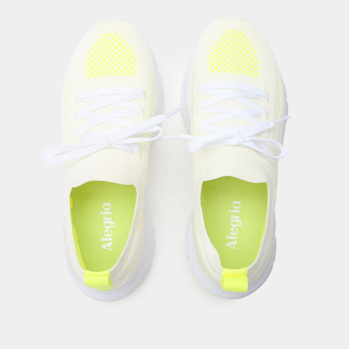White sneakers with neon green accents on a light gray background
