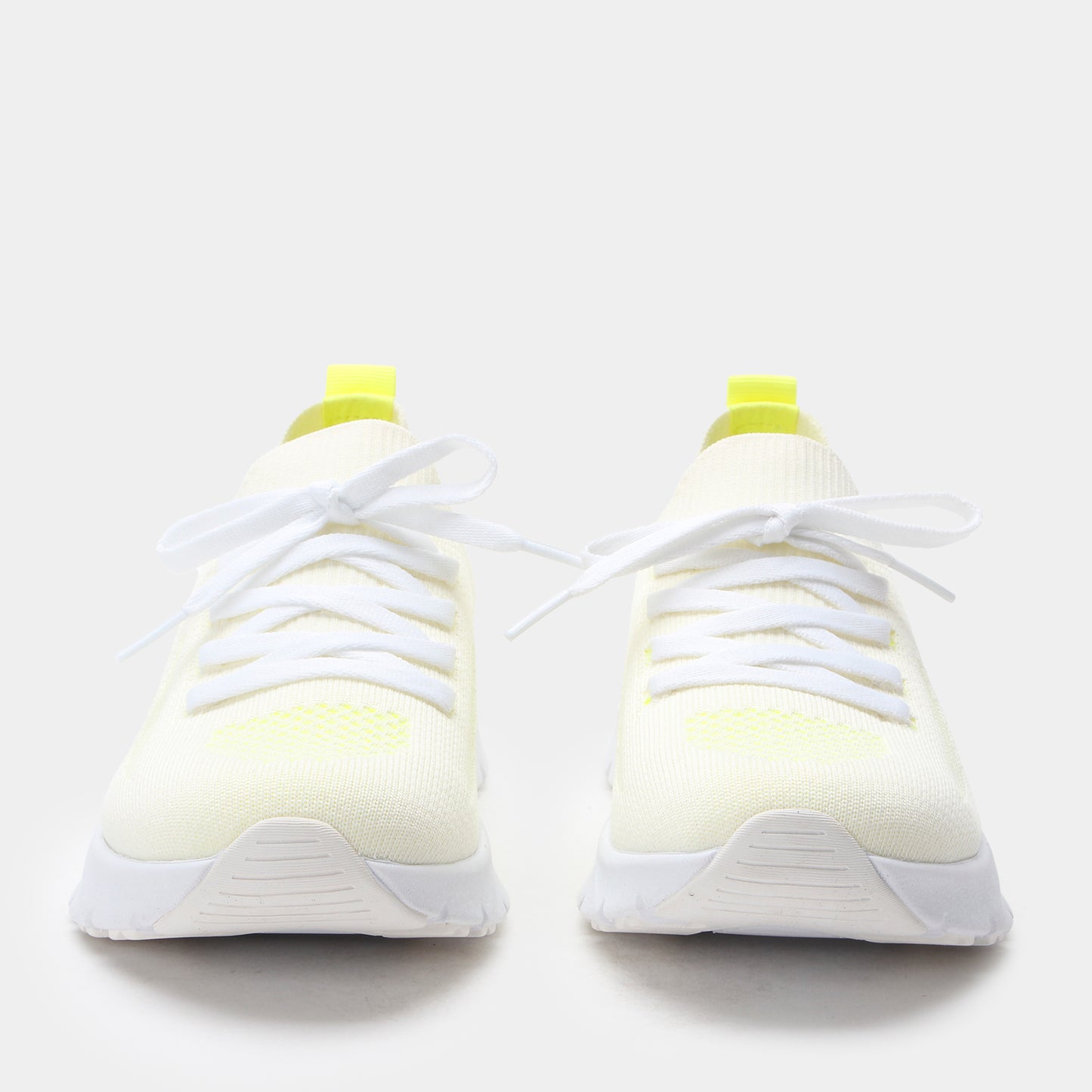 White sneakers with yellow accents on a white background