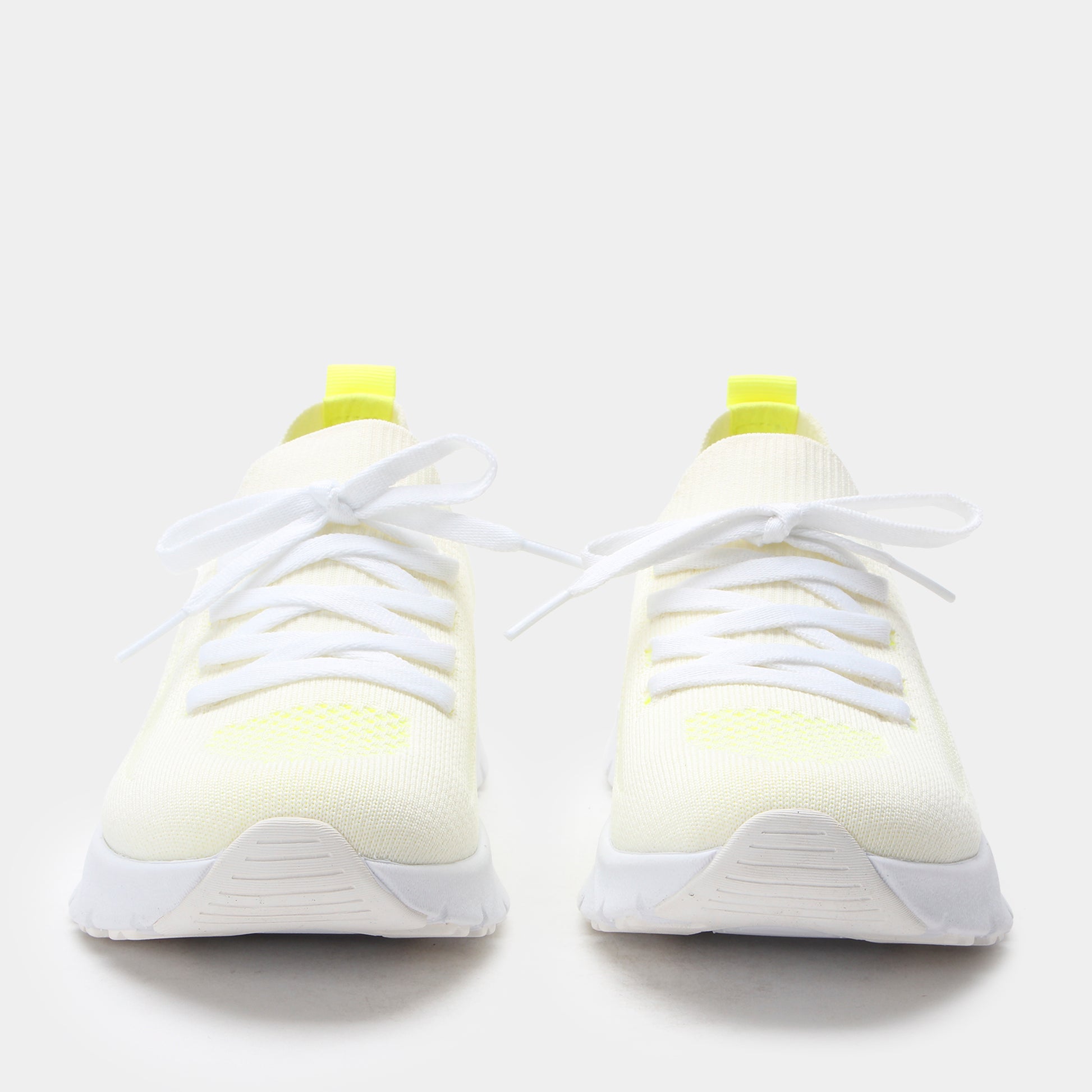 White sneakers with yellow accents on a white background