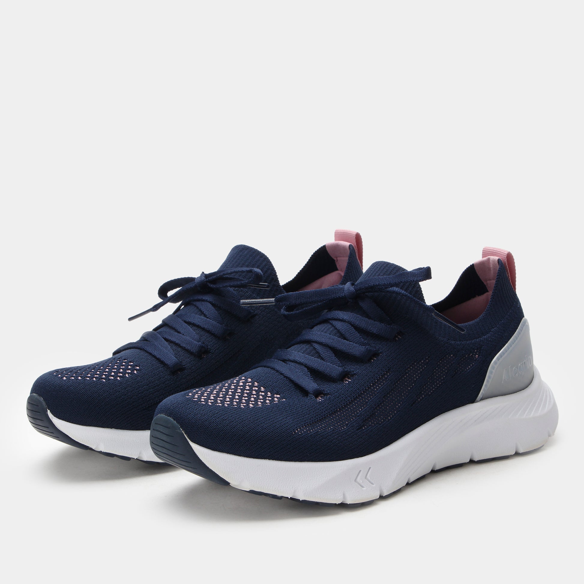 Navy blue athletic shoes with white soles on a light gray background