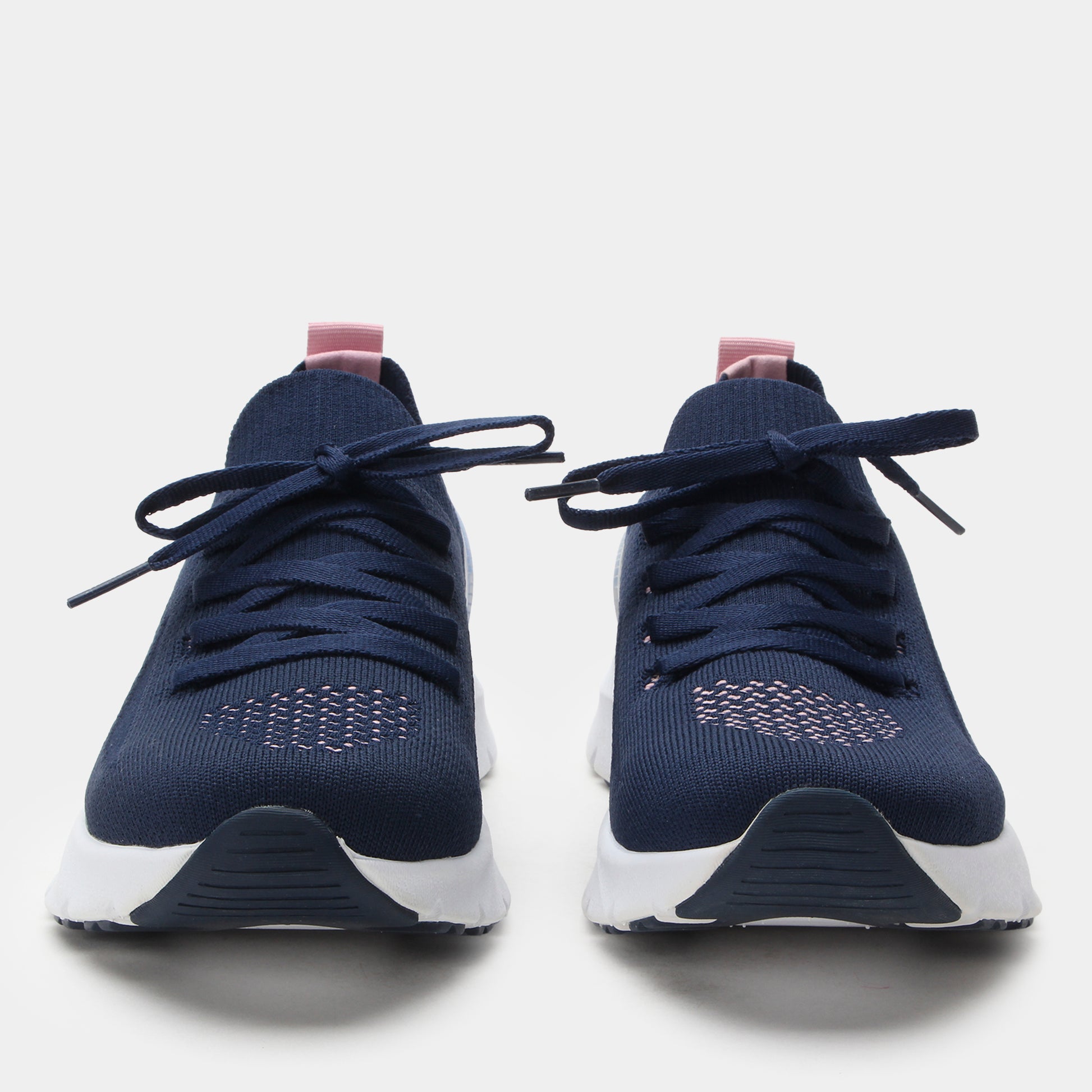 Pair of navy blue sneakers with white soles on a light gray background