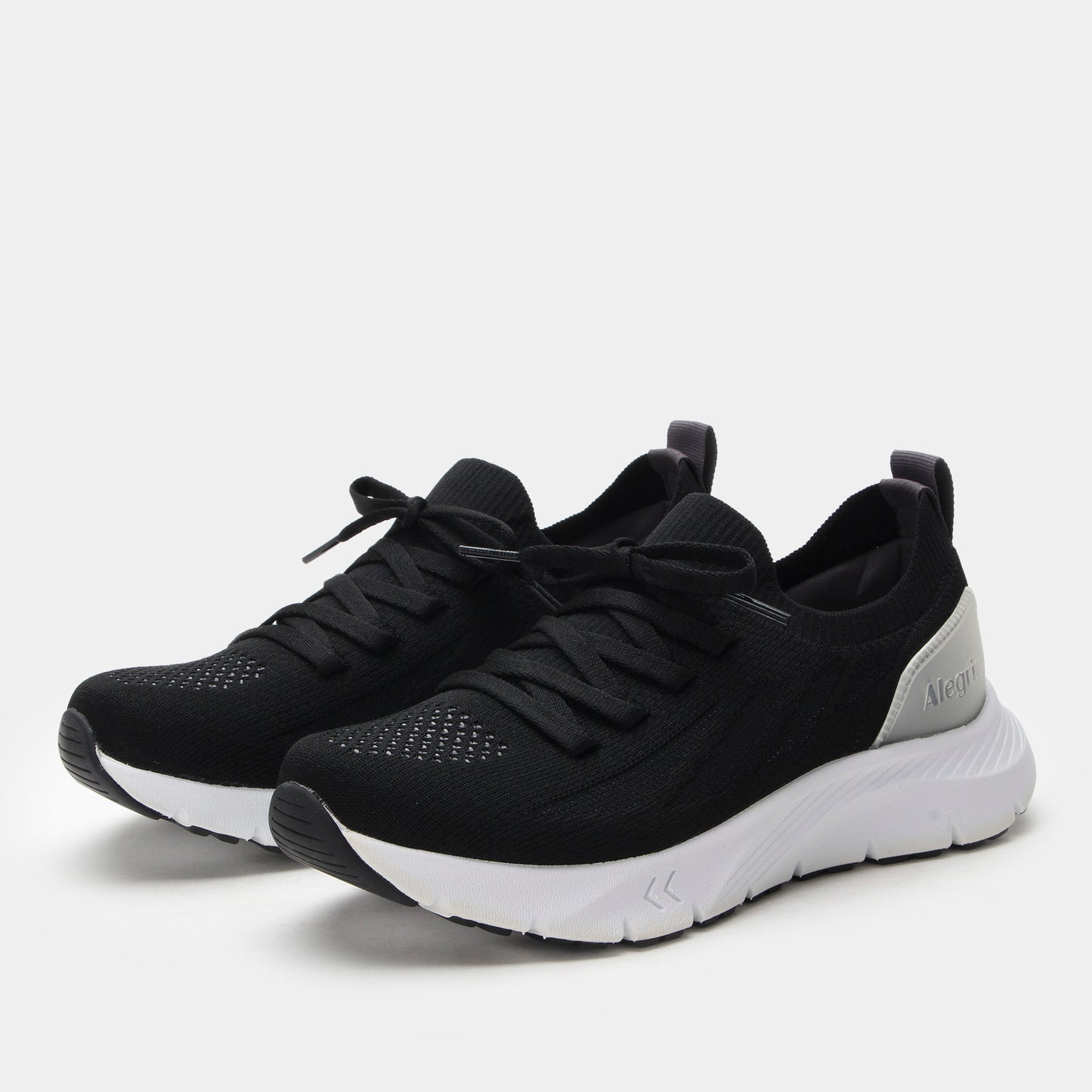 Black athletic shoes with white soles on a light gray background