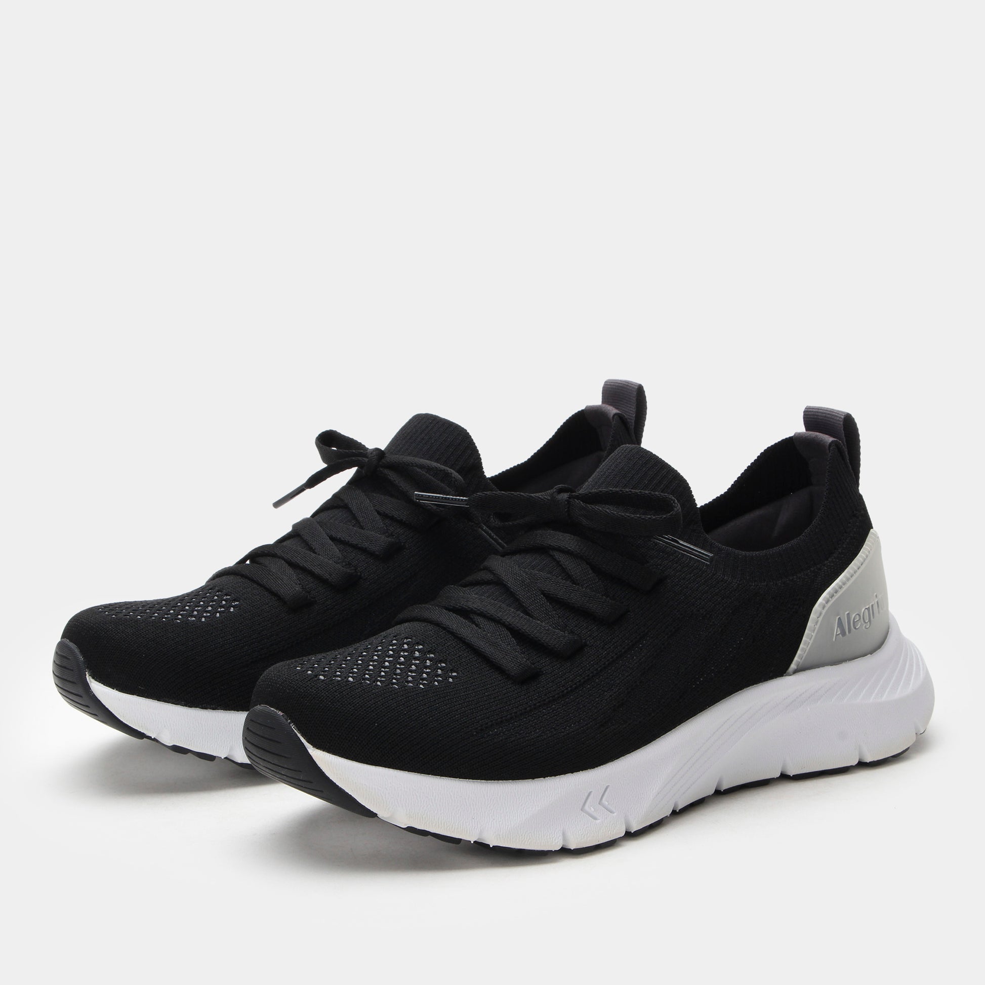 Black athletic shoes with white soles on a light gray background