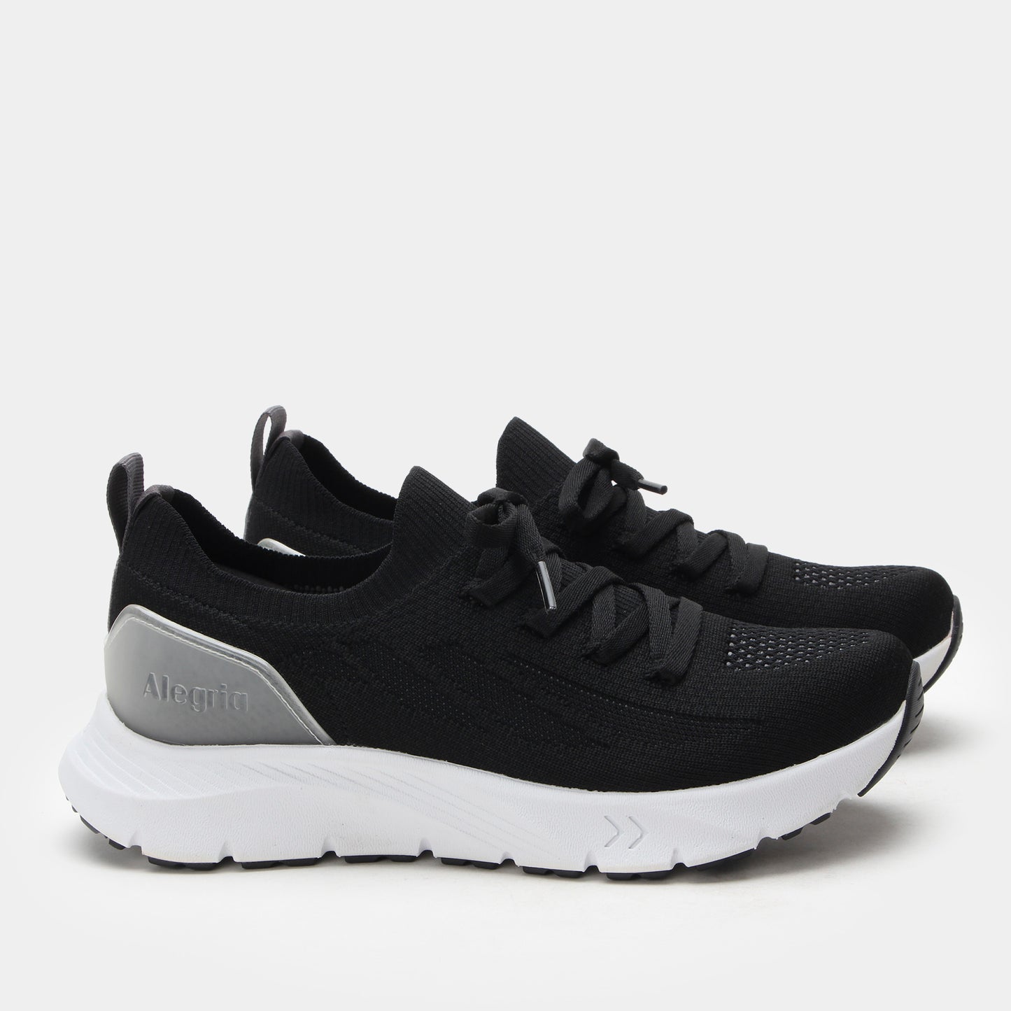 Black running shoes with white soles on a light gray background