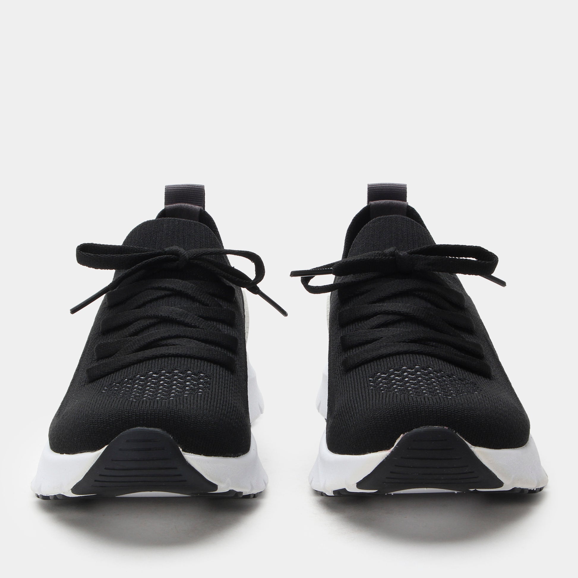 Black athletic shoes with white soles on a light gray background