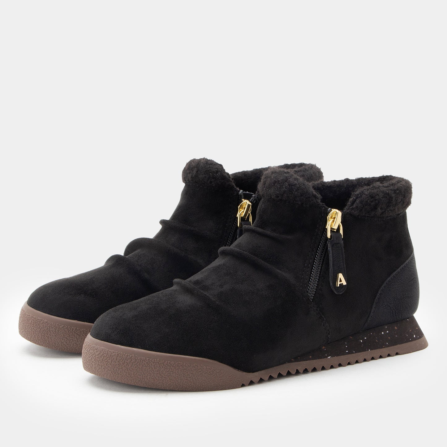 A pair of black suede ankle boots with plush faux-fur trim, side zippers with gold-tone hardware, and brown textured soles, shown on a light gray background.