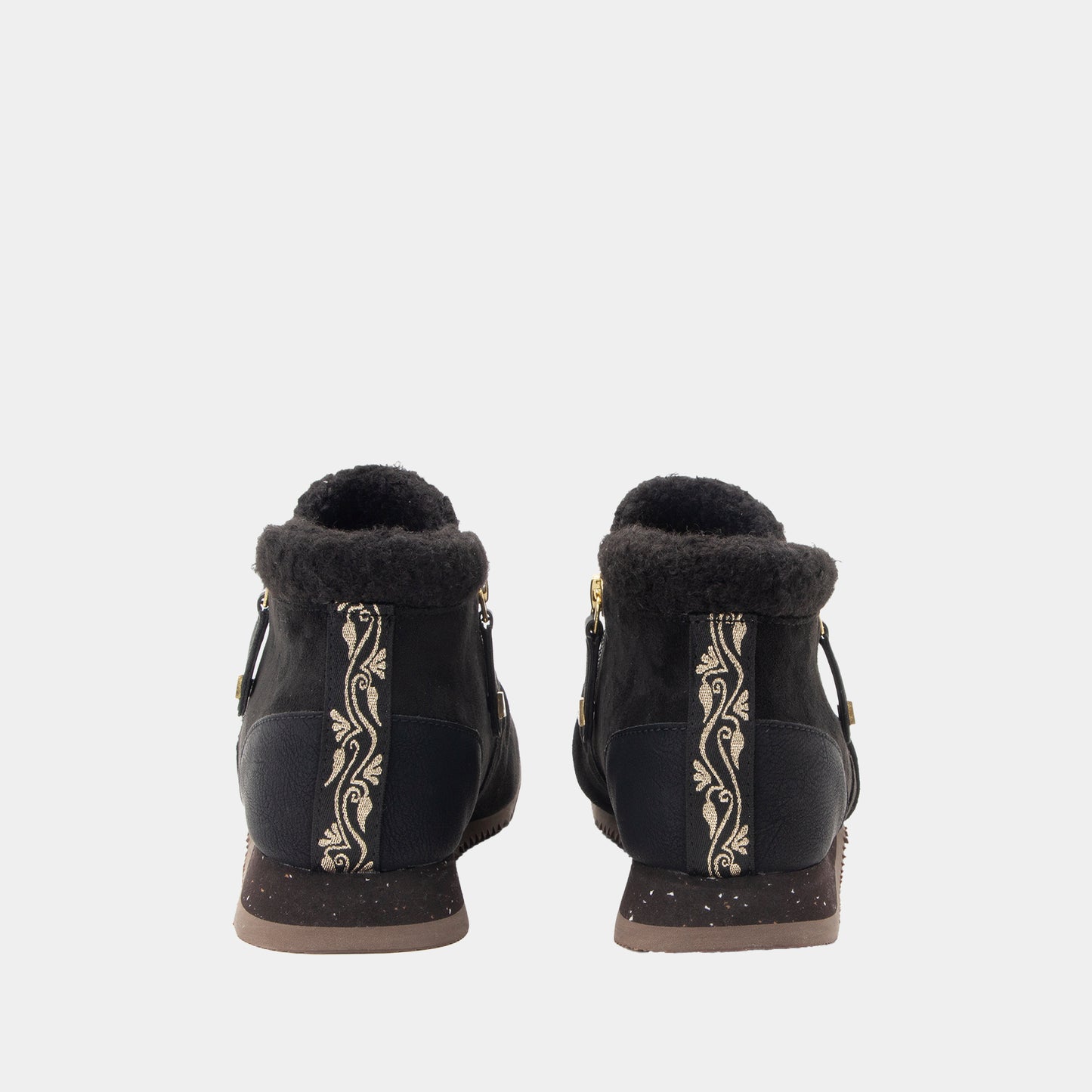 A pair of black ankle boots with shearling trim, featuring vertical gold floral embroidery on the sides and gold-tone hardware, shown from the back against a light gray background.