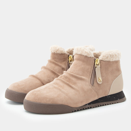 A pair of beige suede ankle boots with fluffy cream faux-fur lining, side zippers with gold-tone hardware, and dark brown soles, shown on a light gray background.