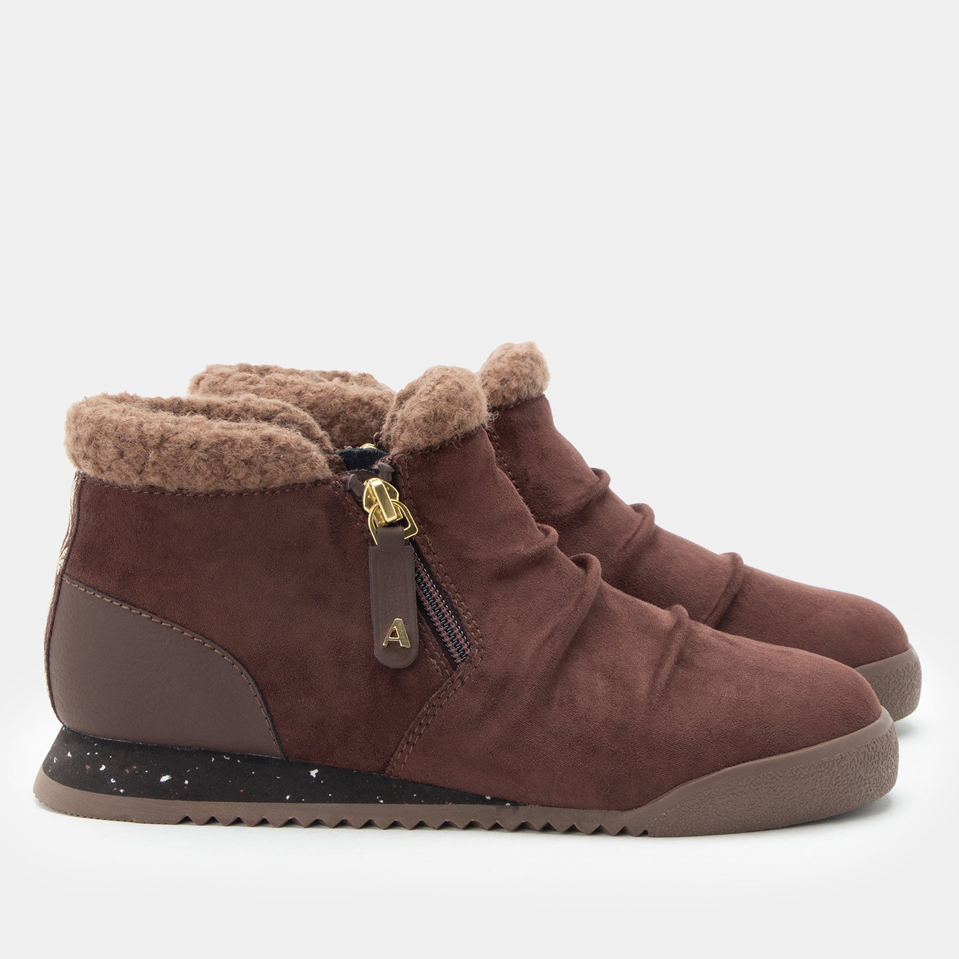 A pair of women's brown suede ankle boots with a plush tan shearling lining, side zippers, and a speckled black sole, shown against a light gray background.