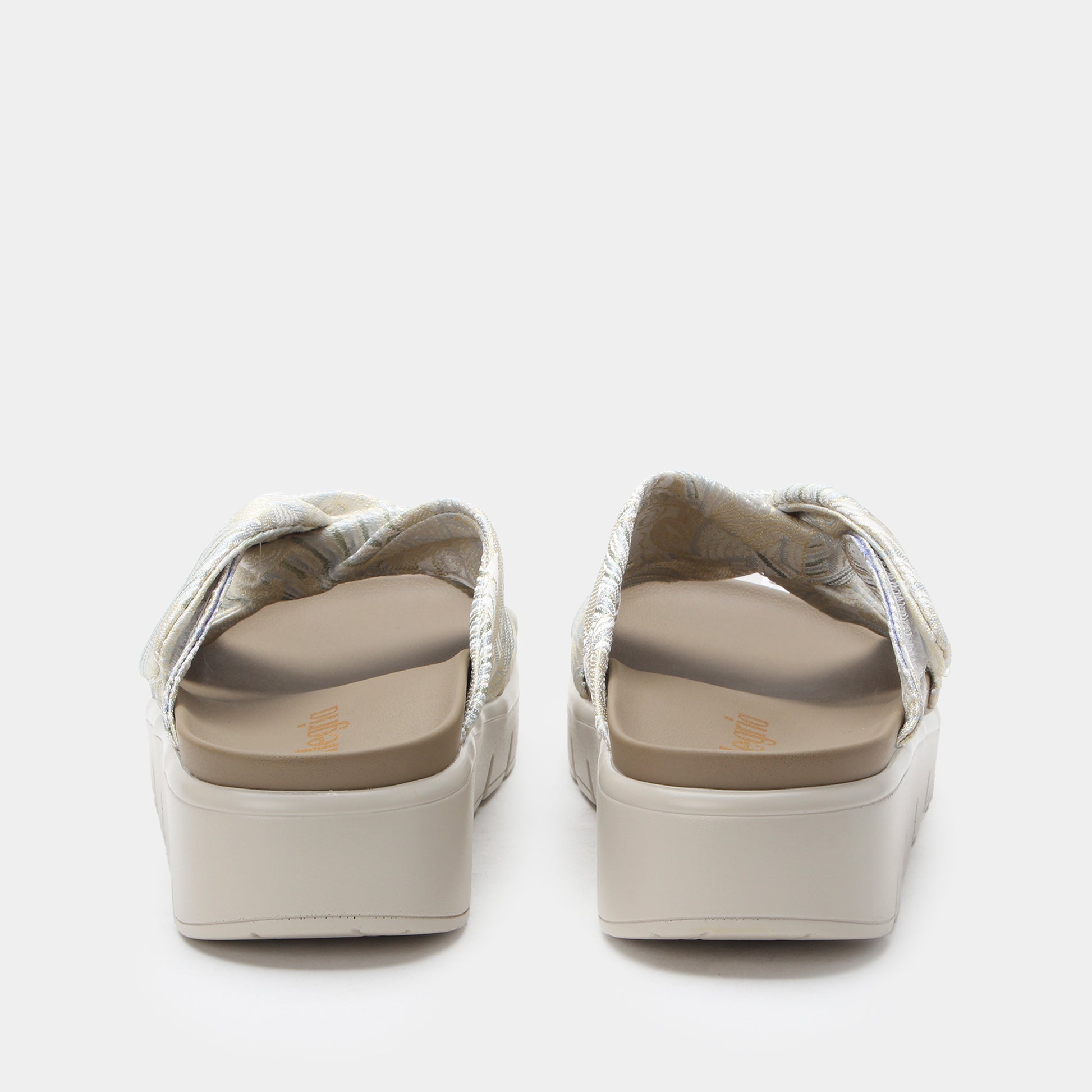 Pair of white sandals with beige soles on a light gray background