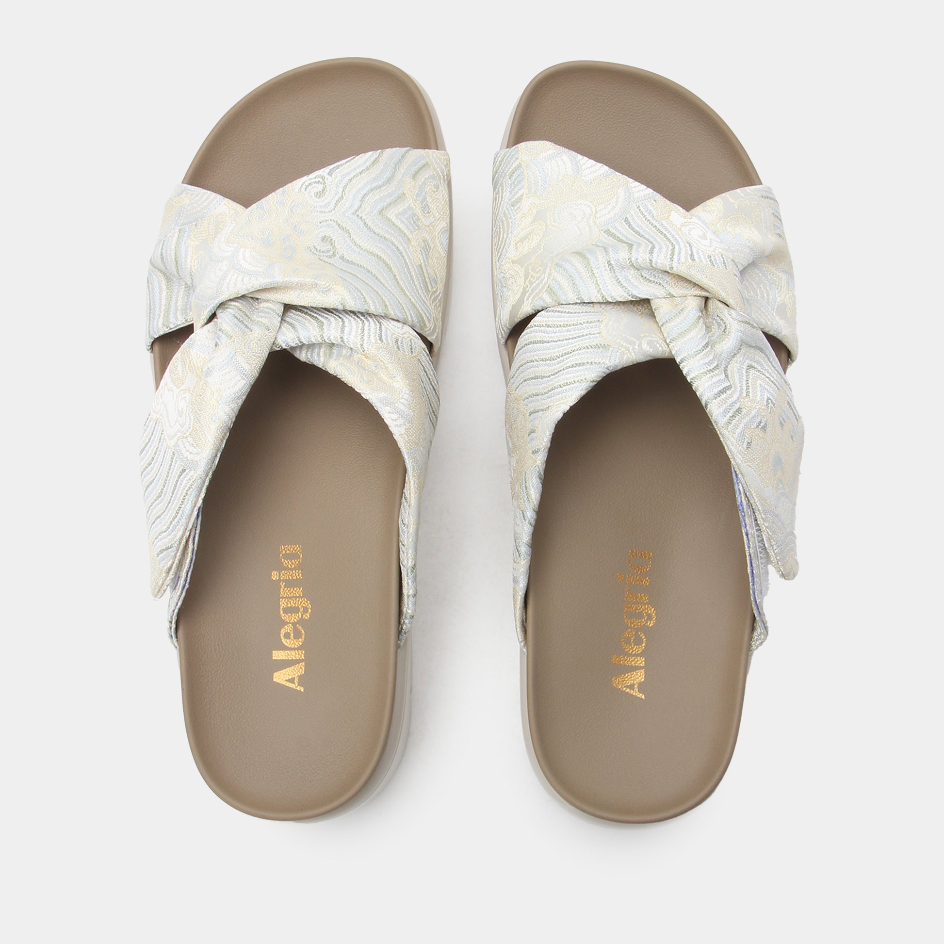 Pair of white sandals with a bow design on a light gray background, featuring the brand 'Allegria'.