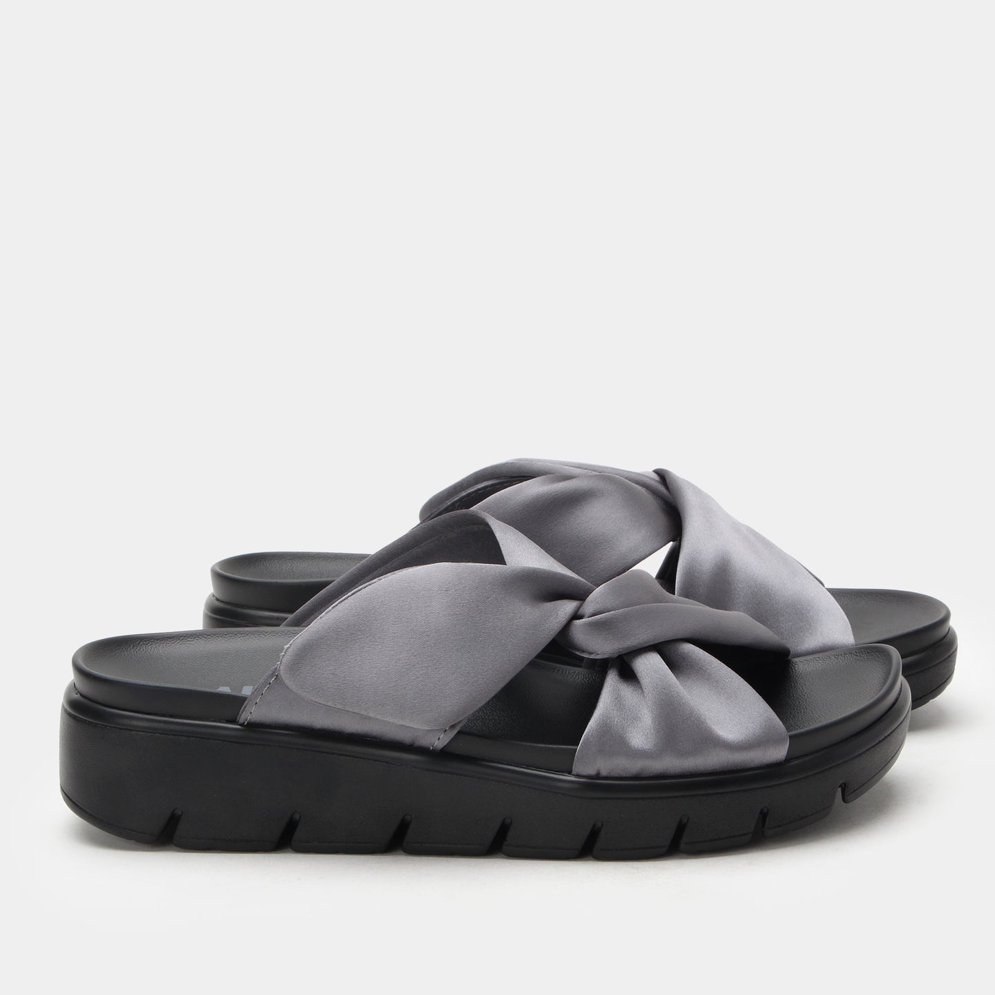 Black sandal with a large gray bow on a light gray background