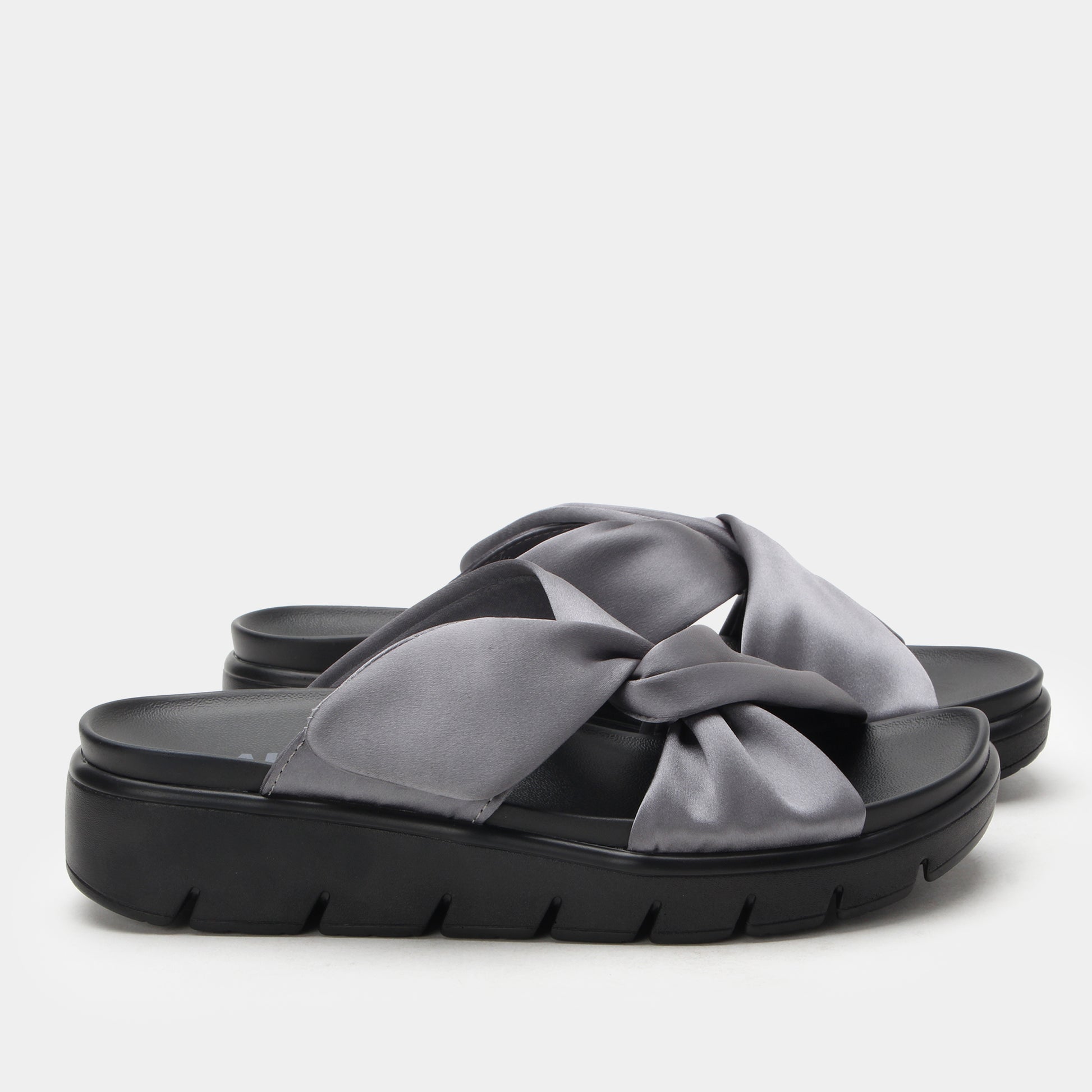 Black sandal with a large gray bow on a light gray background