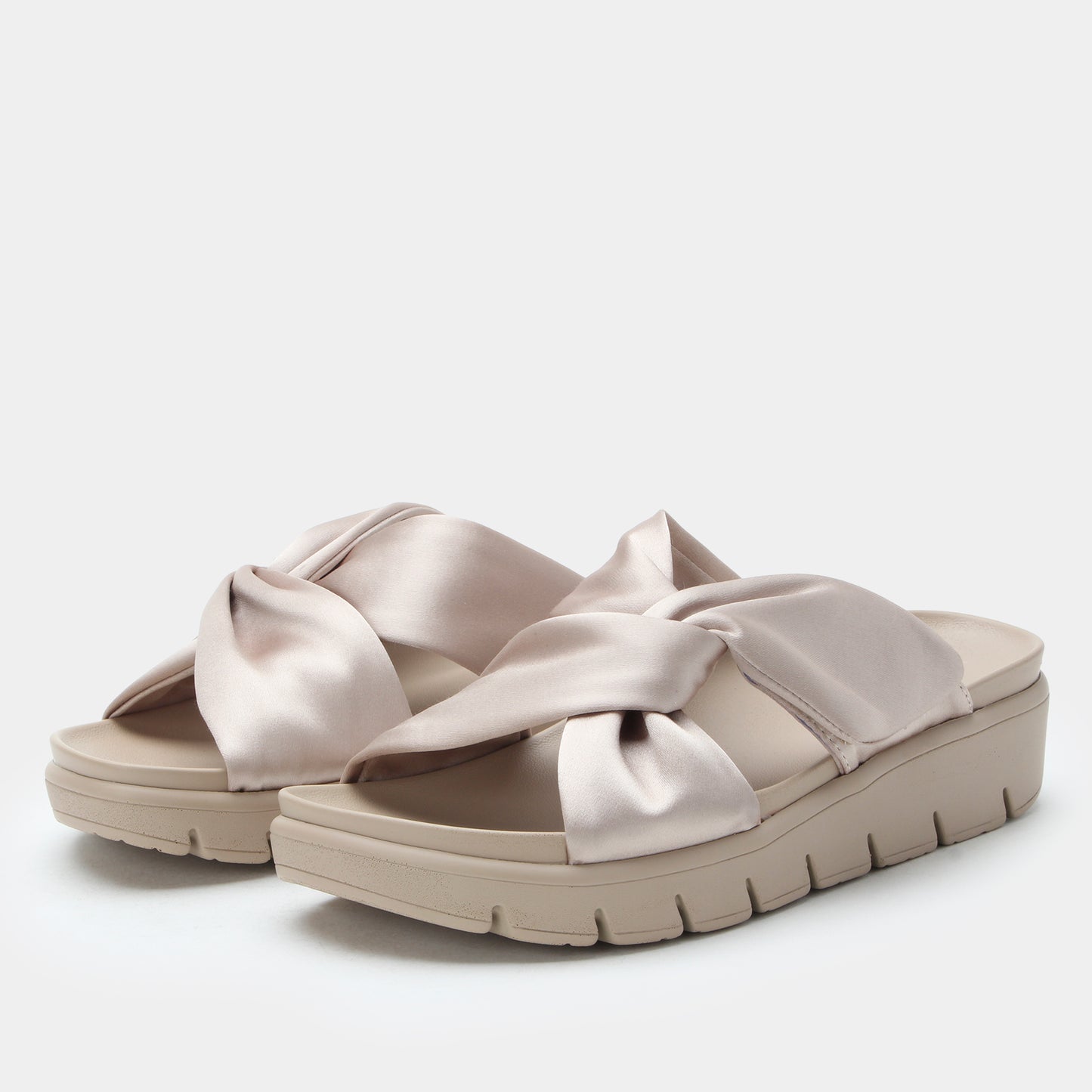 Beige sandals with bow detail on a white background