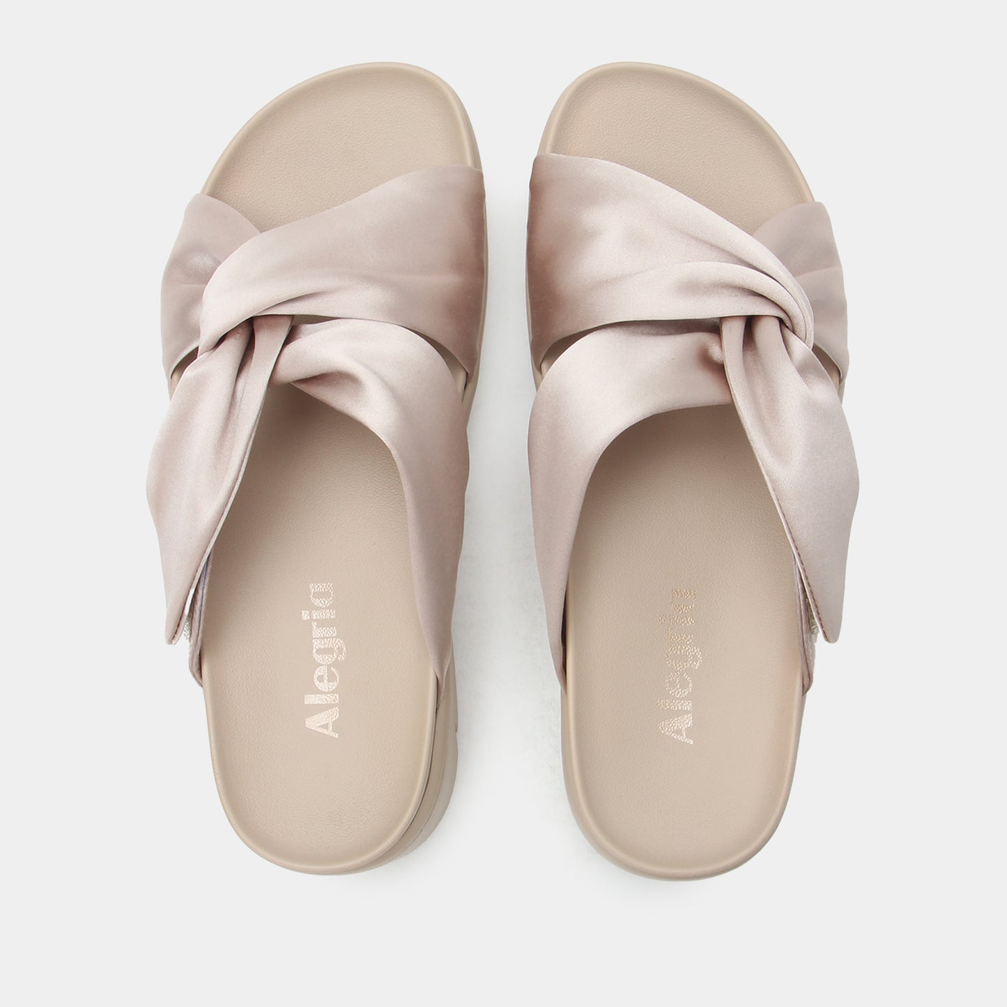 Pair of beige sandals with a bow design on a white background