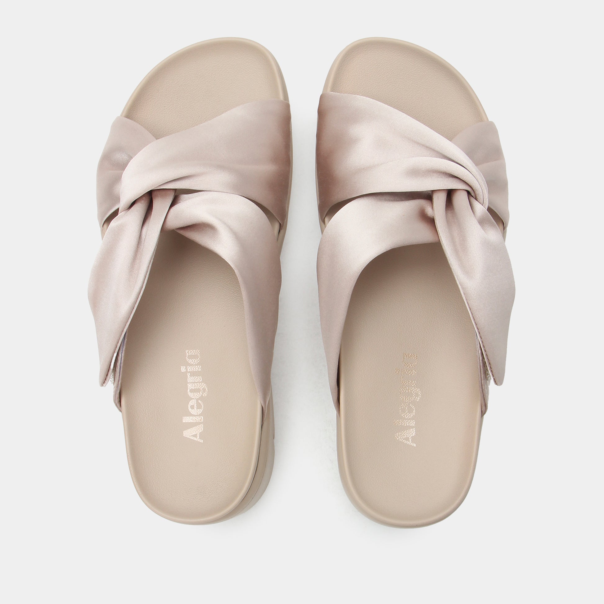 Pair of beige sandals with a bow design on a white background