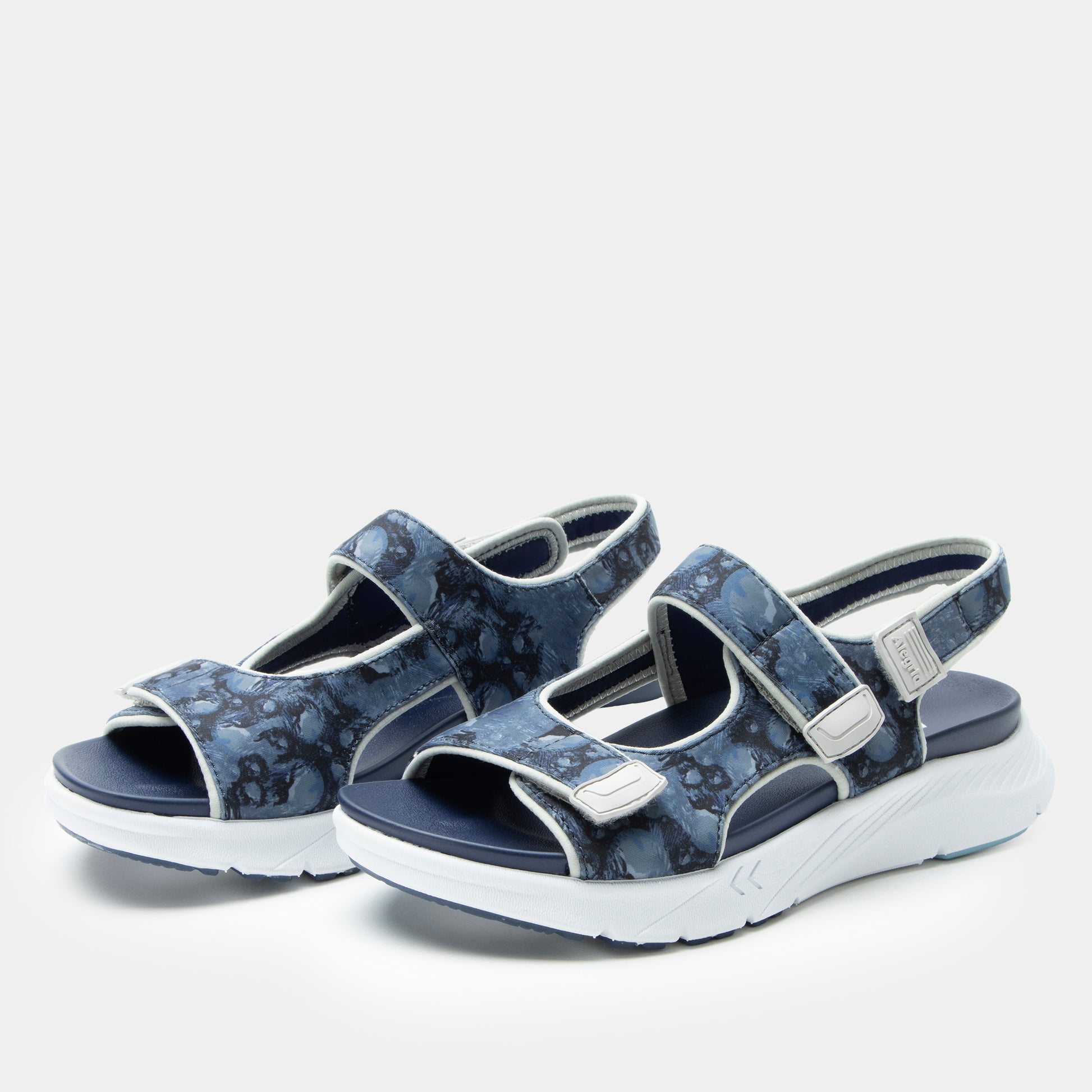 Pair of blue floral-patterned sandals on a white background