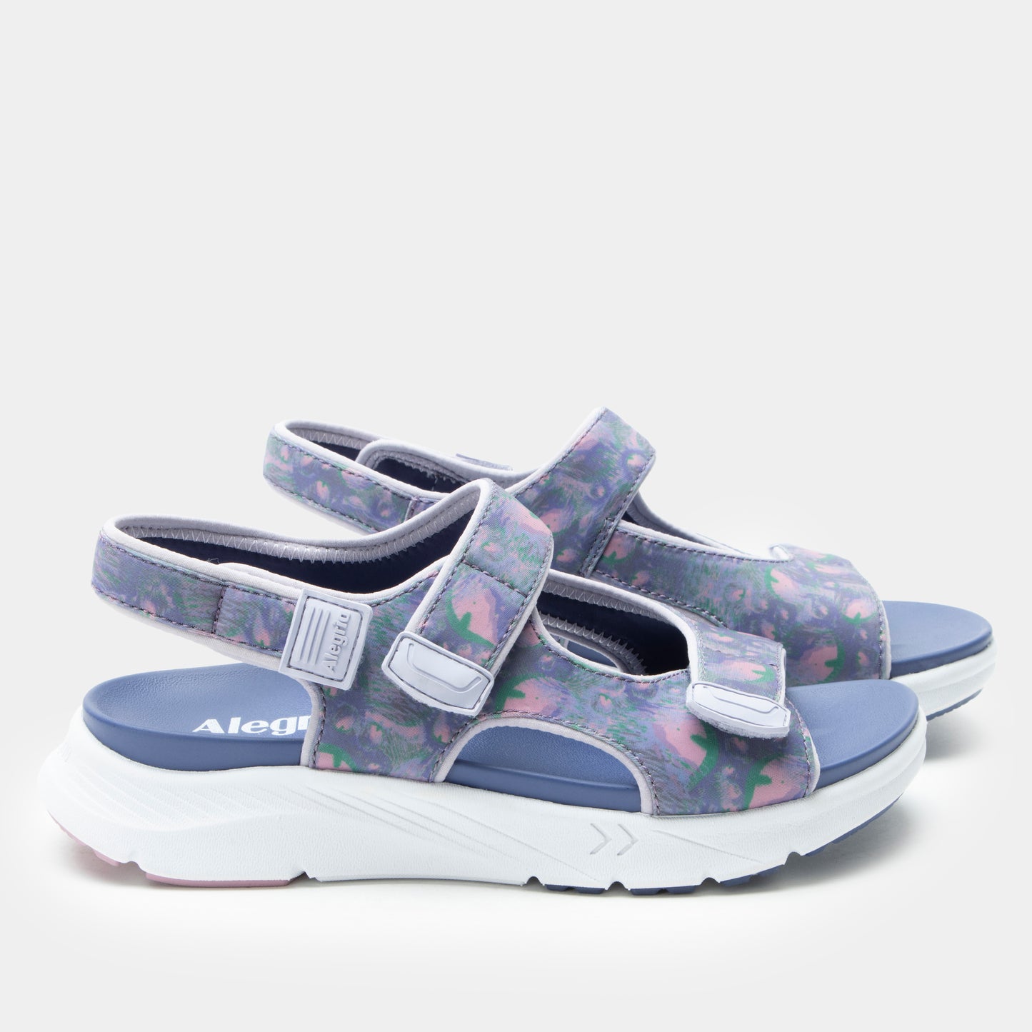 Pair of sandals with floral pattern and blue sole on a white background