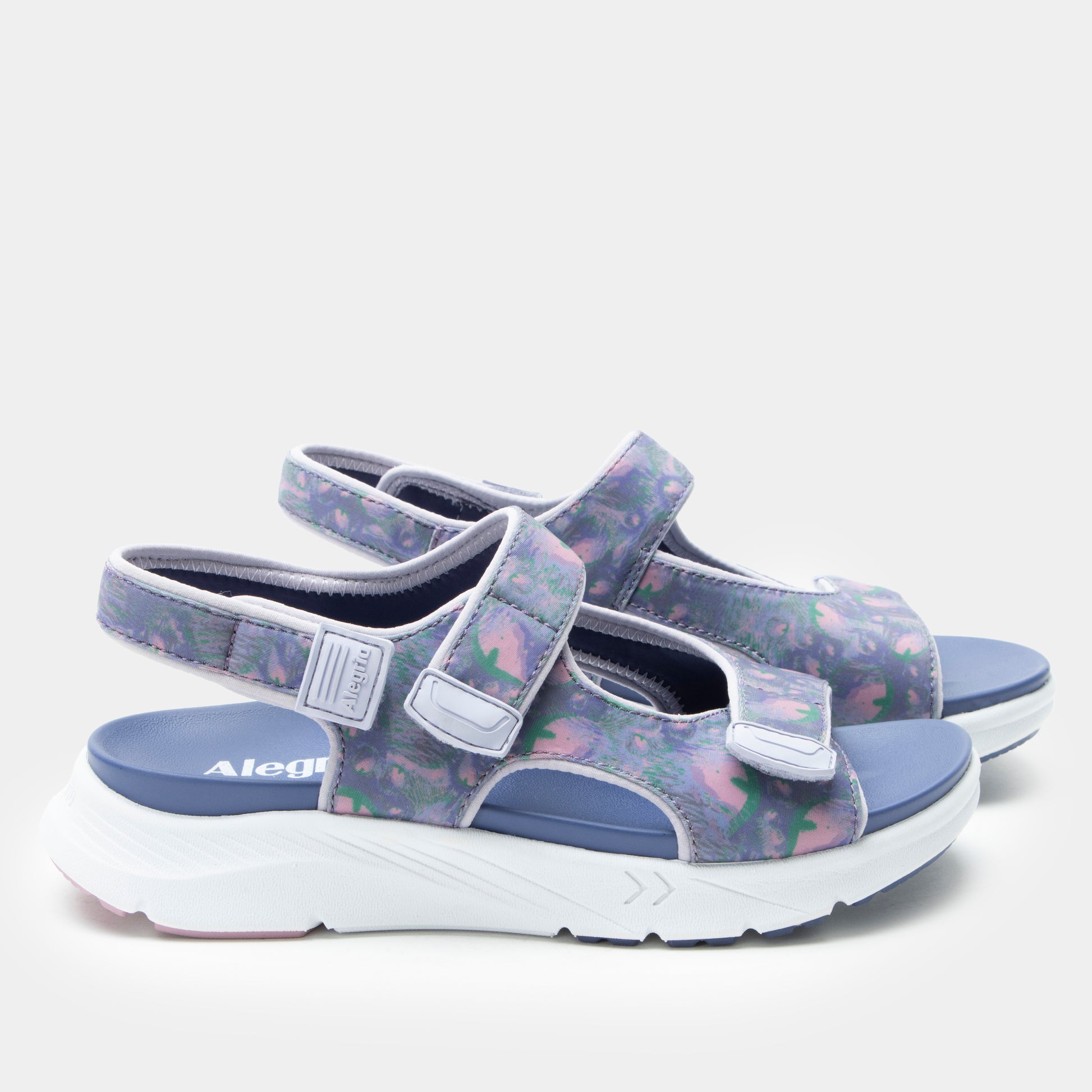 Pair of sandals with floral pattern and blue sole on a white background