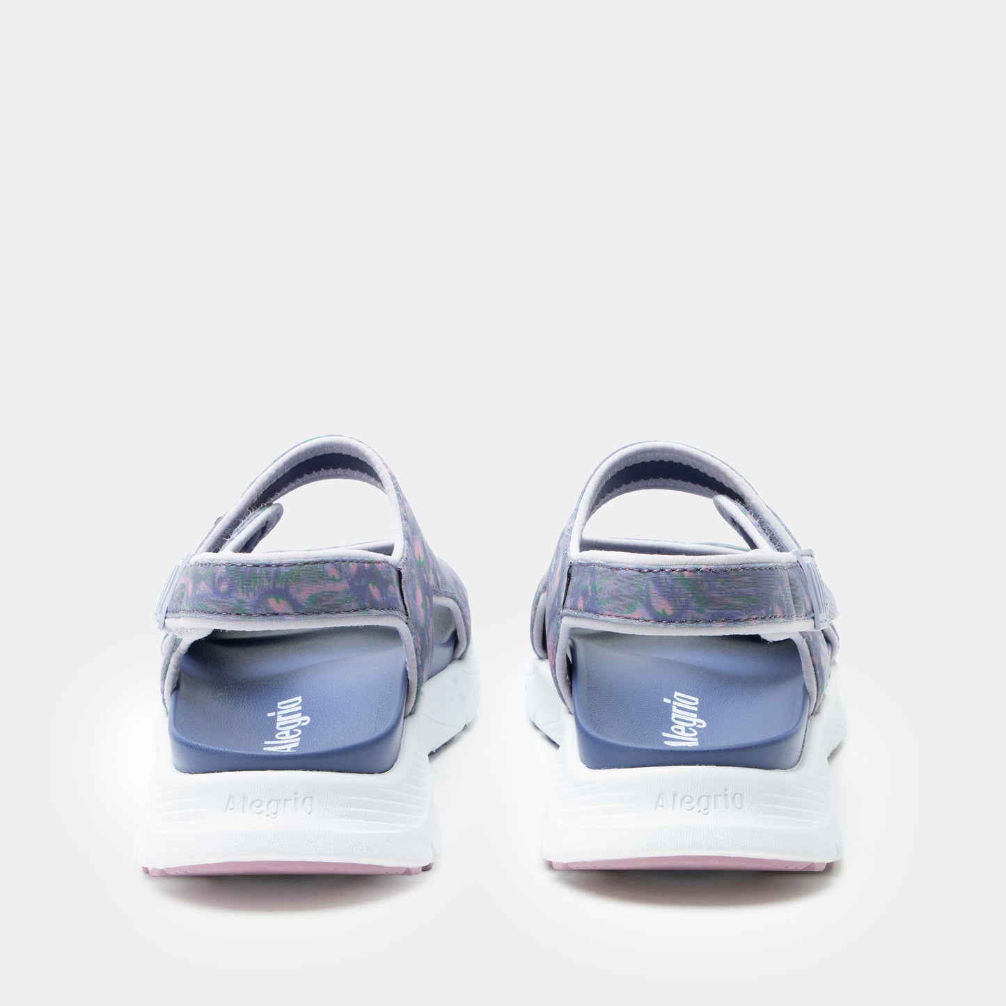 Pair of blue sandals with white soles on a light gray background