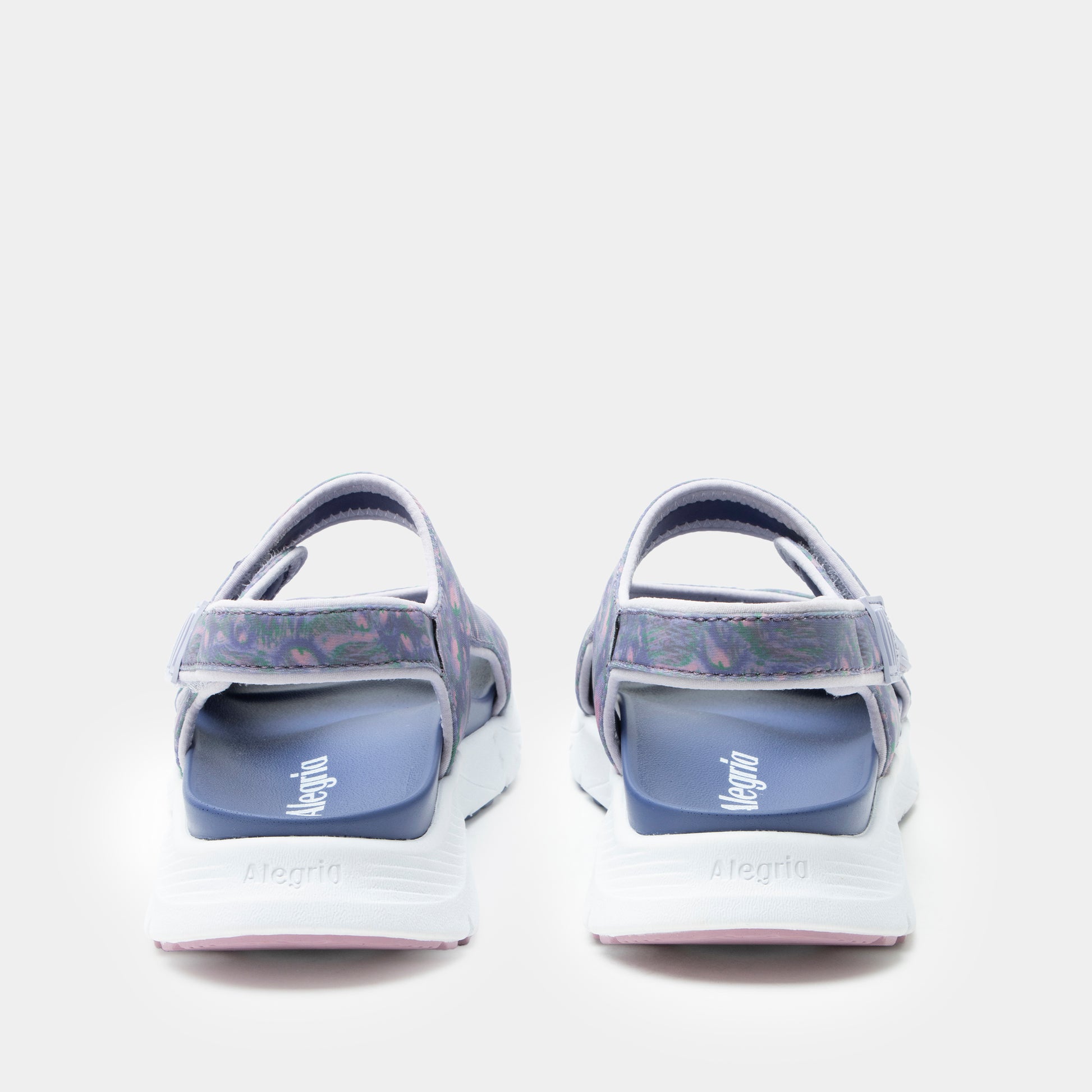 Pair of blue sandals with white soles on a light gray background