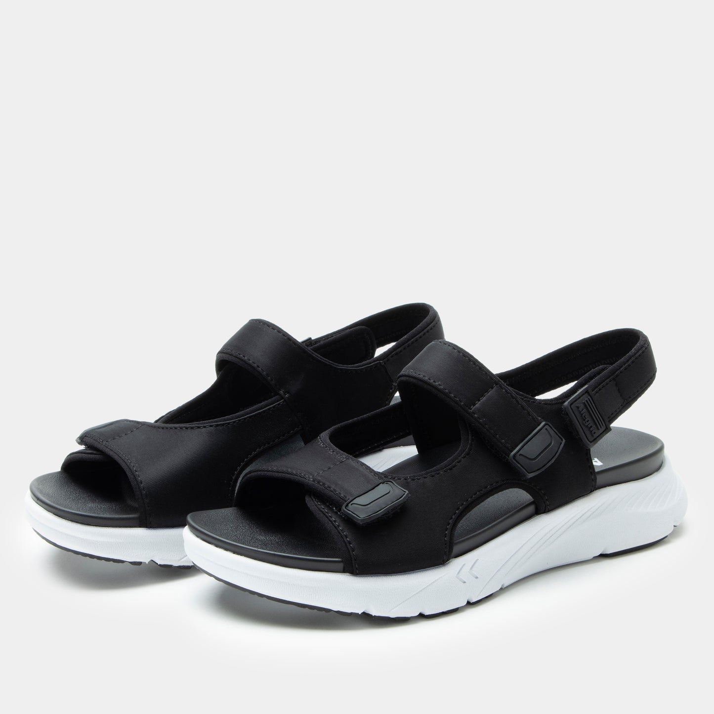 Black sandals with white soles on a light gray background