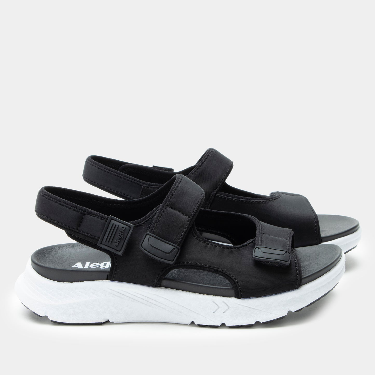 Black sandals with white soles on a light gray background