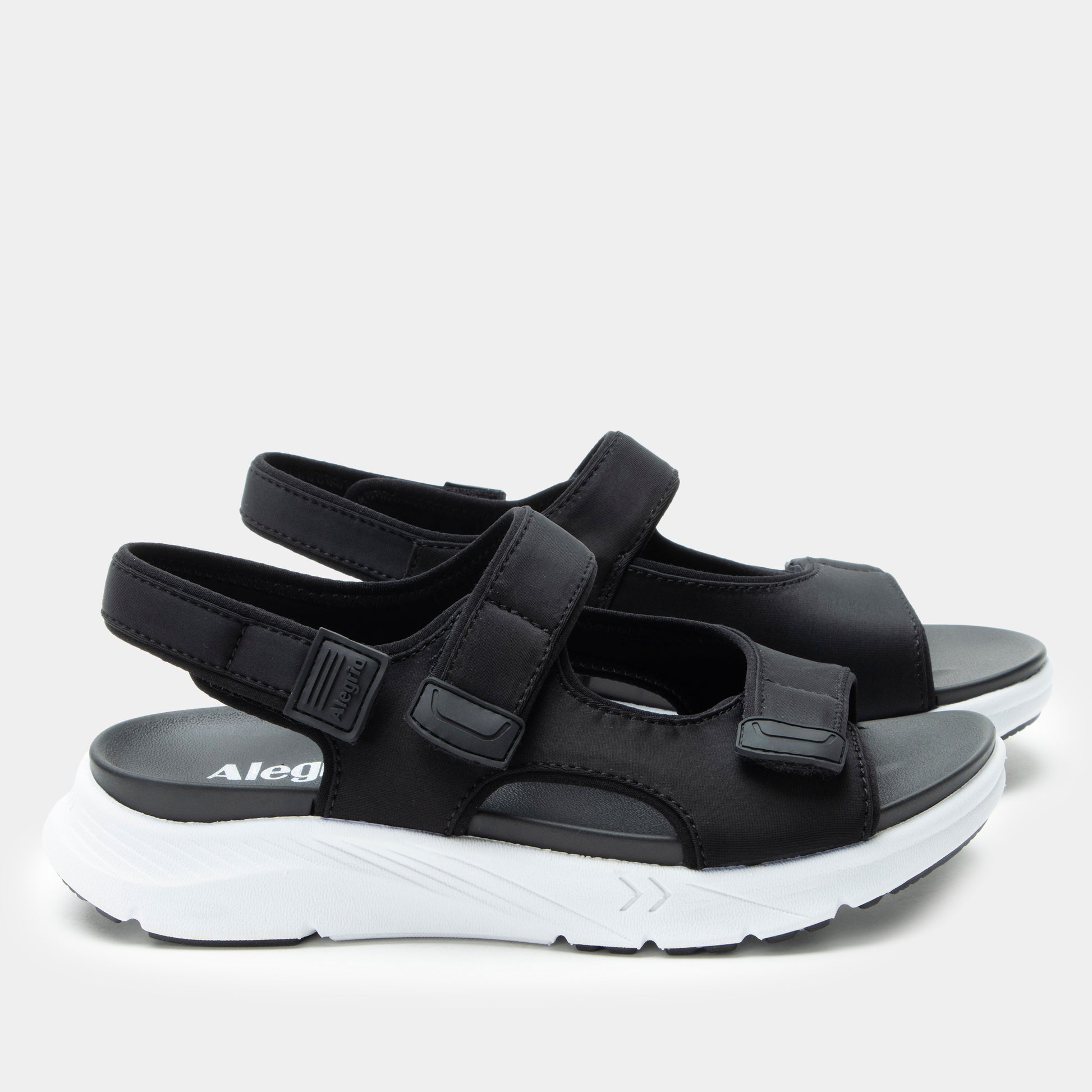 Black sandals with white soles on a light gray background