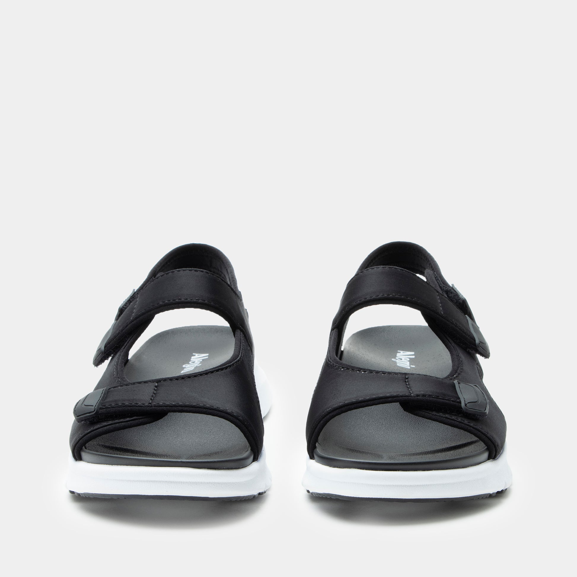 Black sandals with white soles on a light gray background