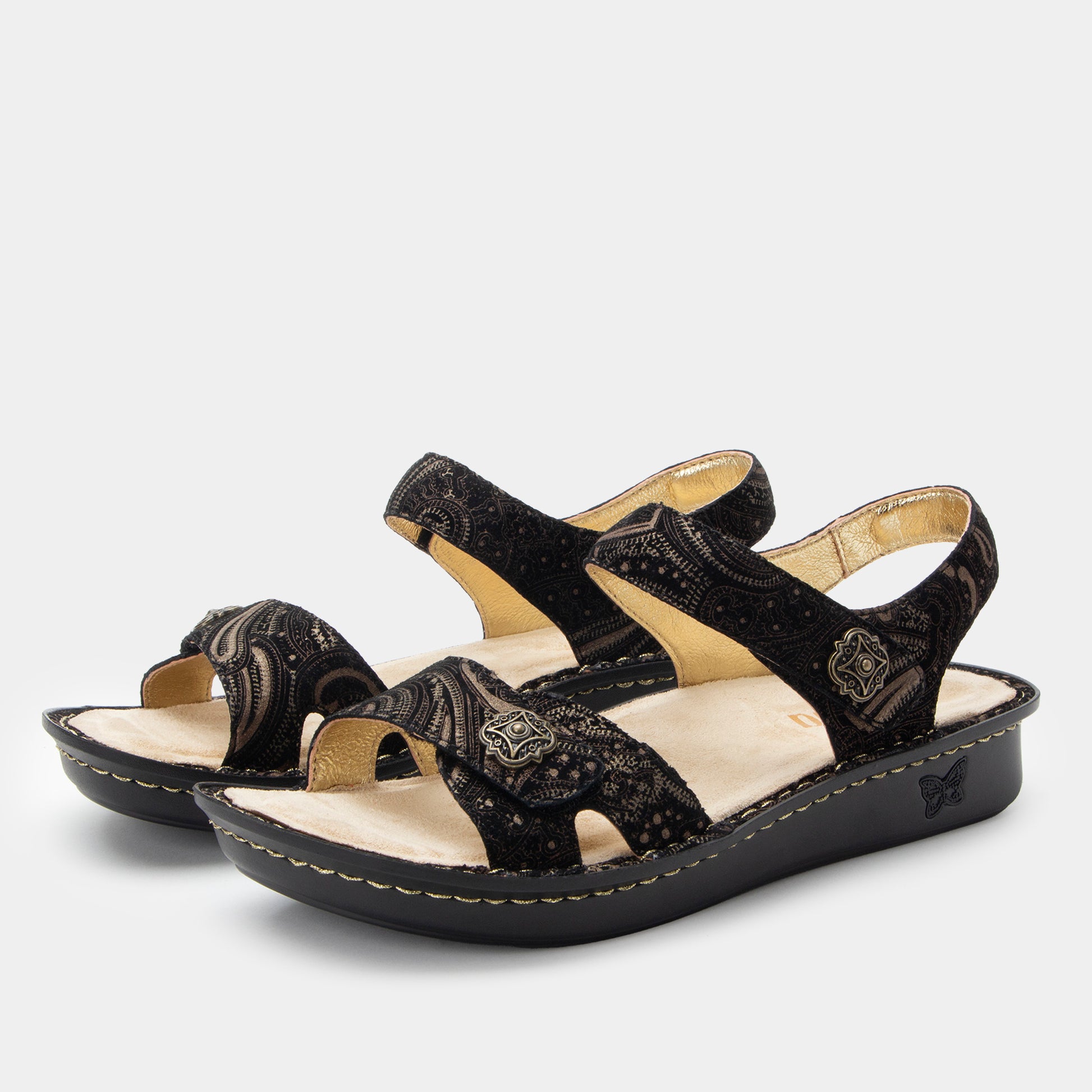 Black sandals with beige soles on a light gray background