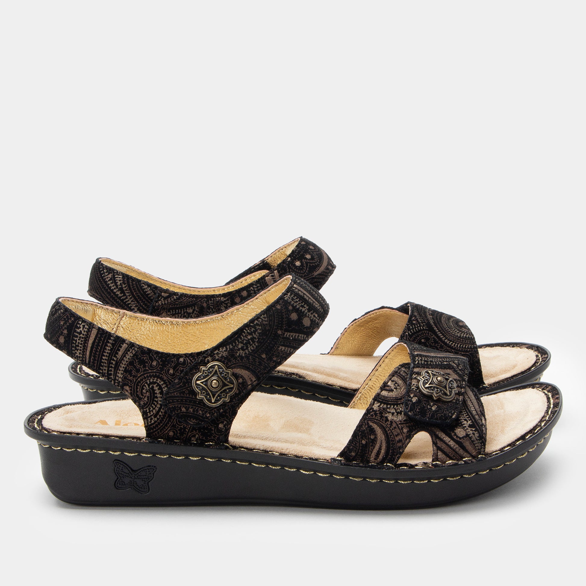Pair of black sandals with beige accents on a white background