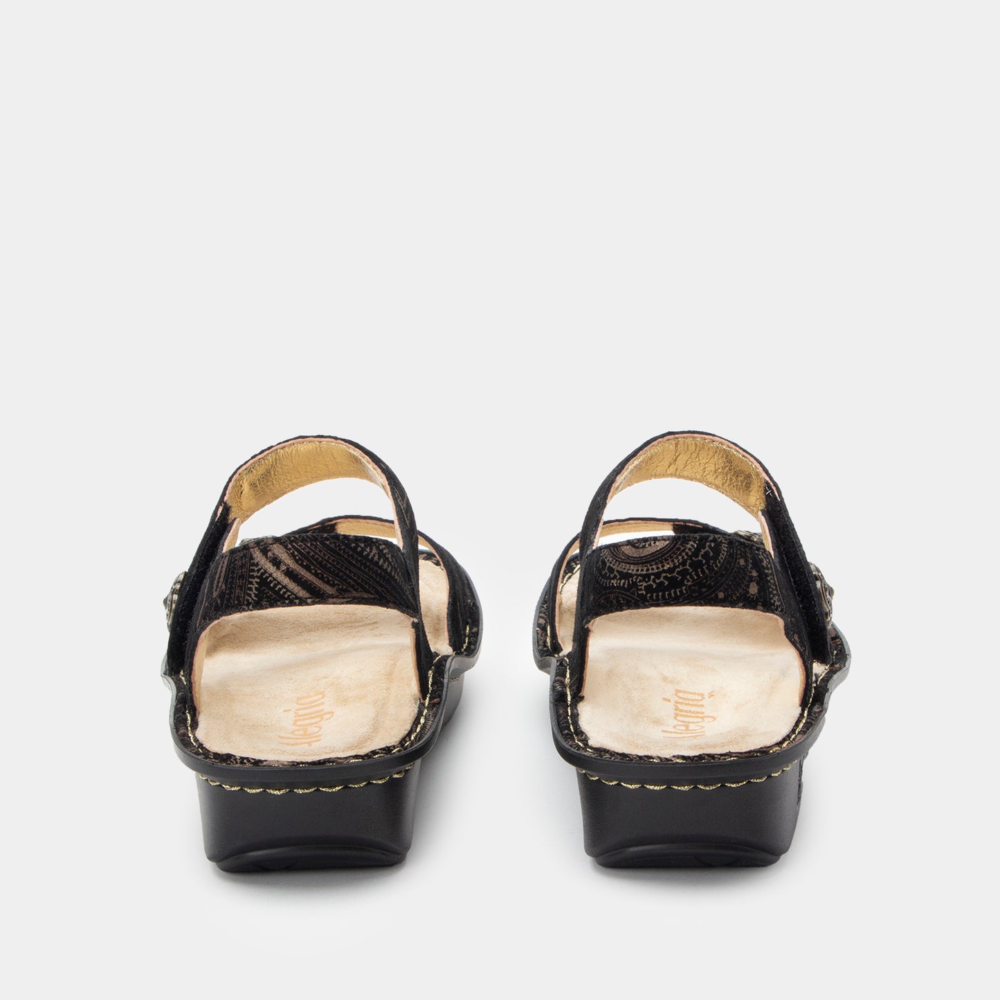 Black sandals with gold accents on a white background