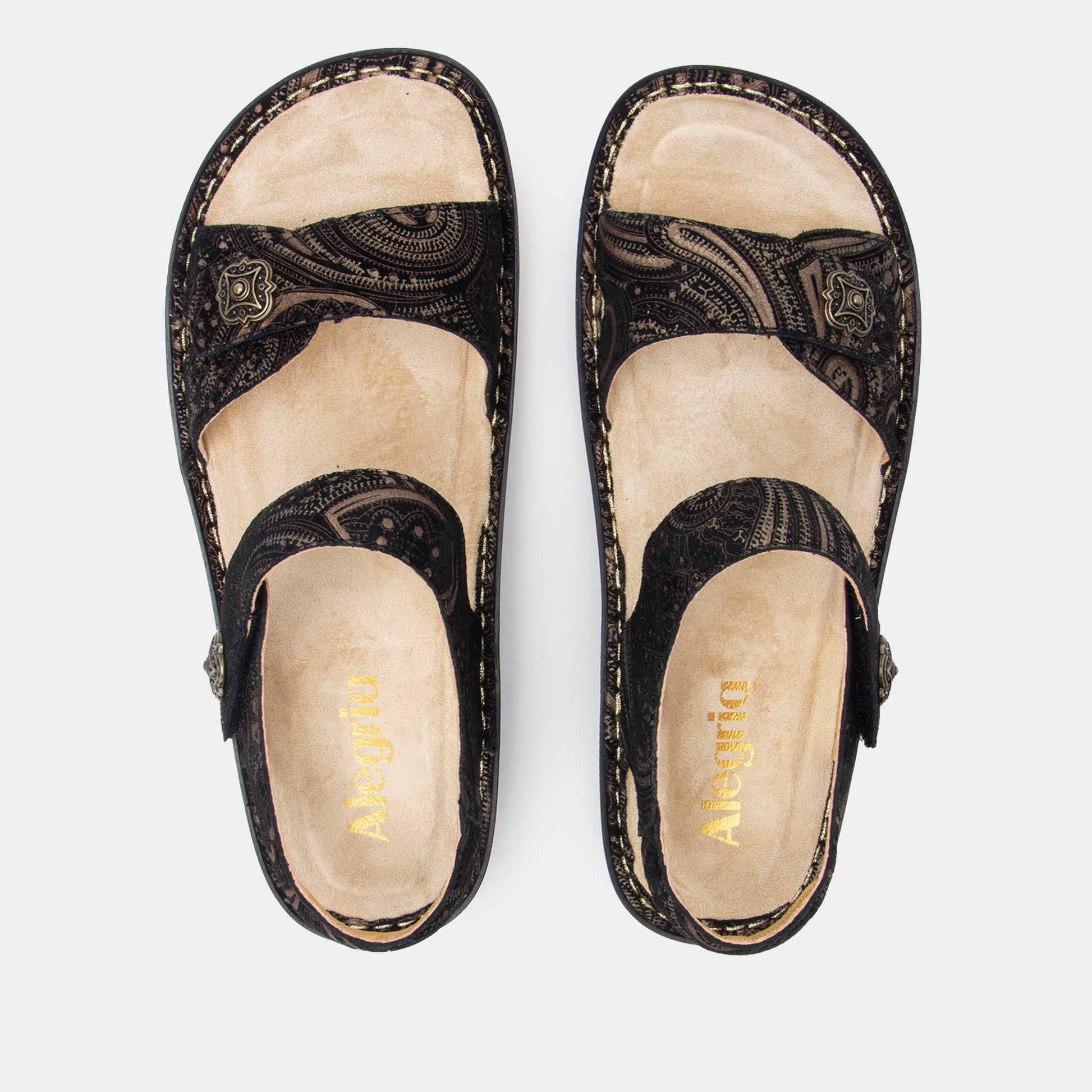 Pair of black sandals with beige soles on a white background