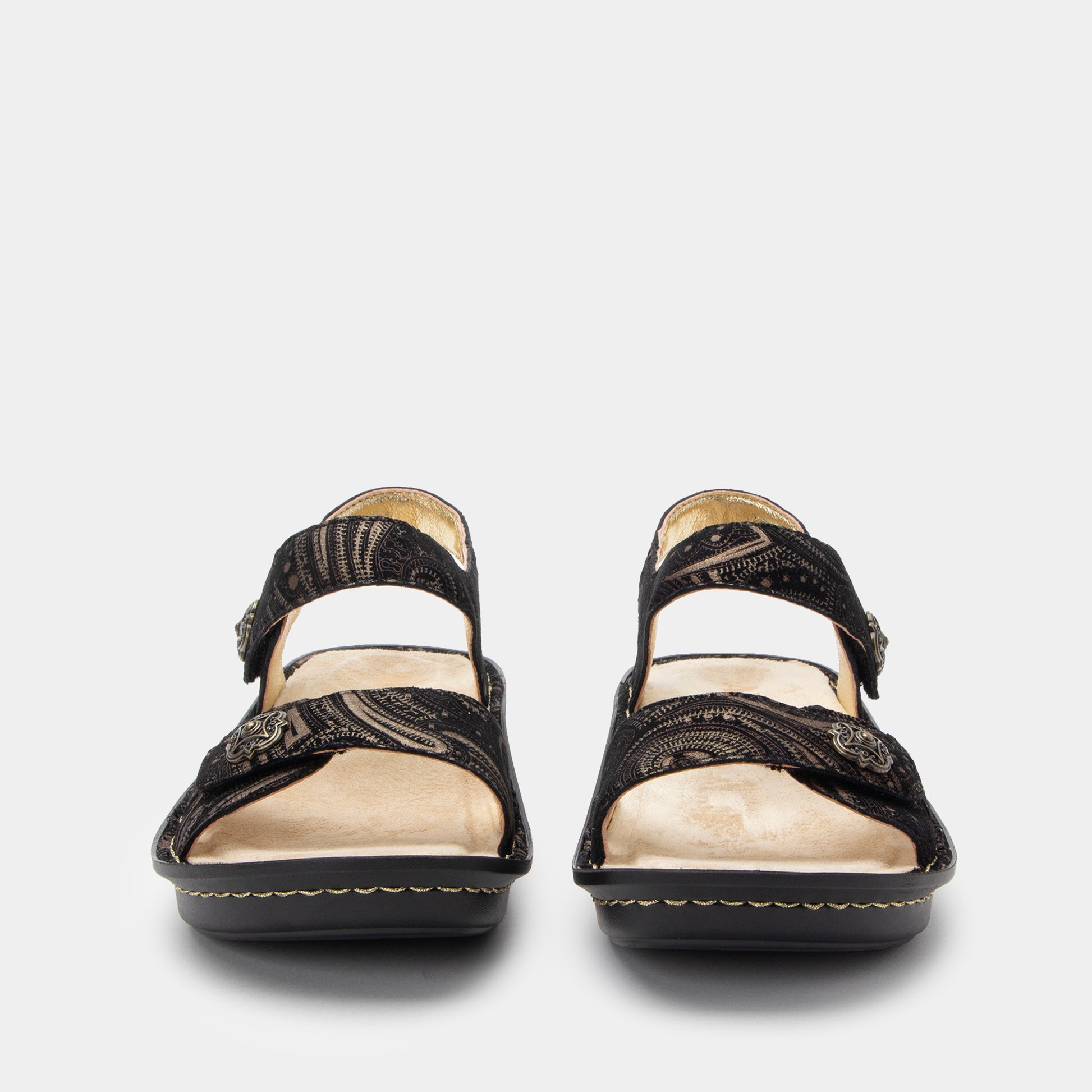 Pair of black sandals with beige soles on a white background