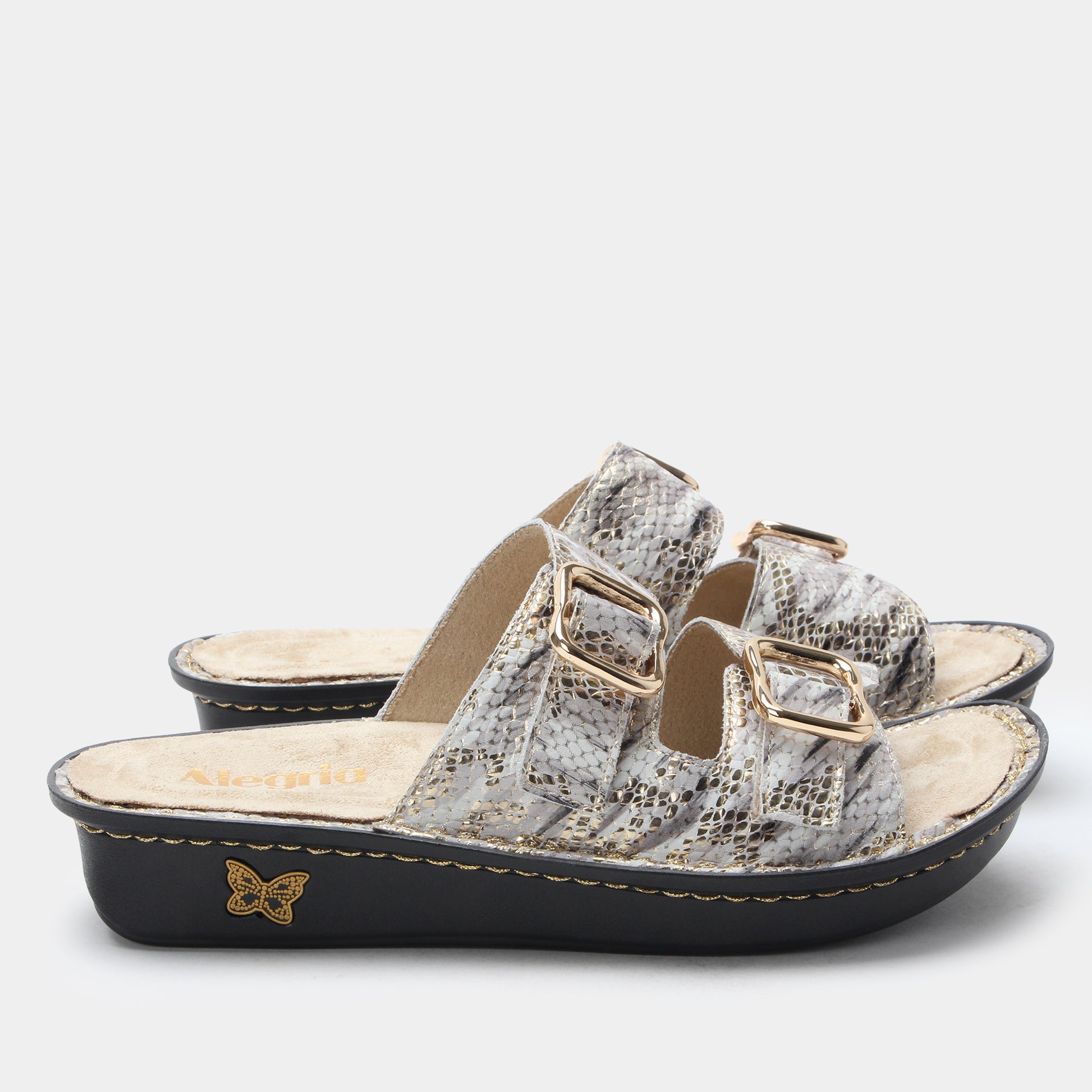 Silver sandal with gold accents on a white background