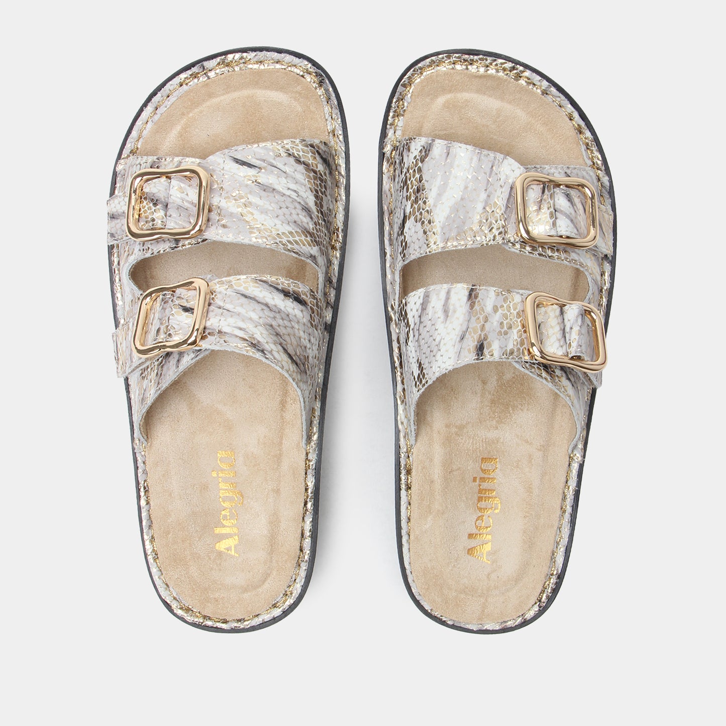 Pair of silver glittery sandals with gold buckles on a light gray background