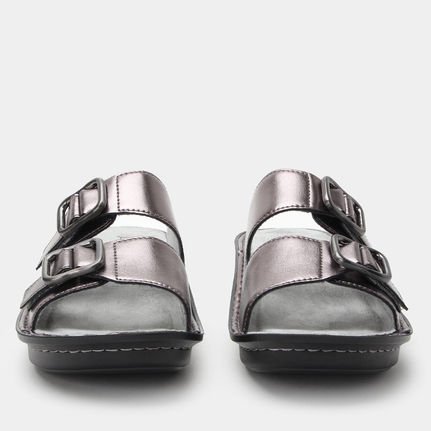 Pair of silver sandals with buckle straps on a light gray background