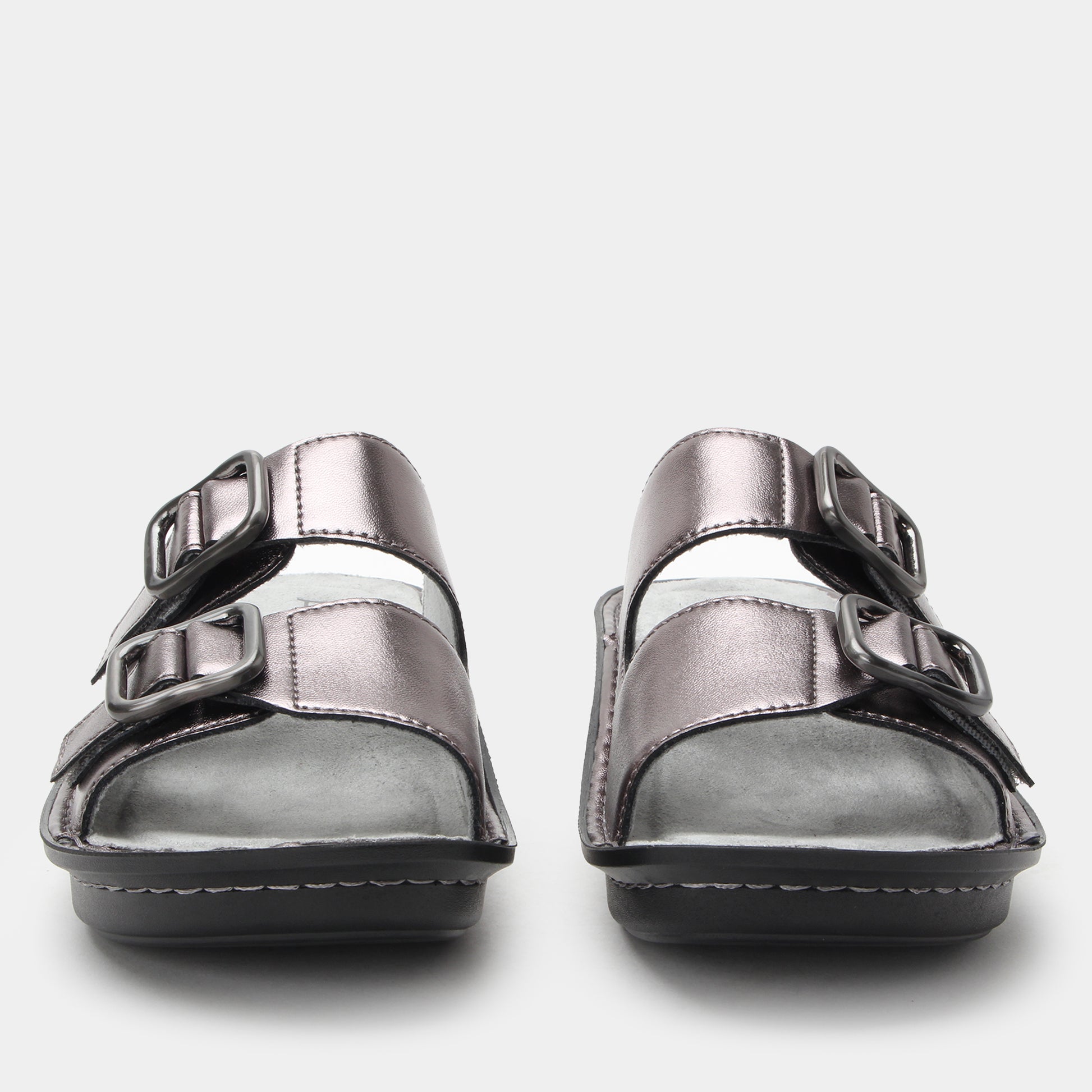 Pair of silver sandals with buckle straps on a light gray background