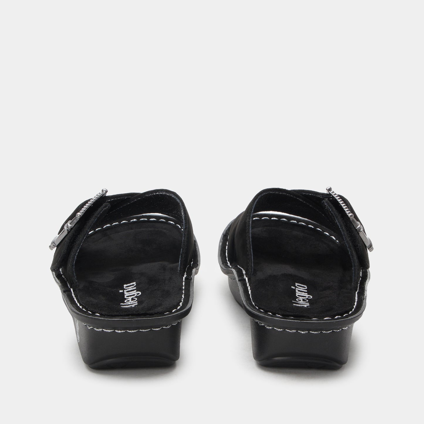 Pair of black sandals with 'Vegano' branding on a light gray background