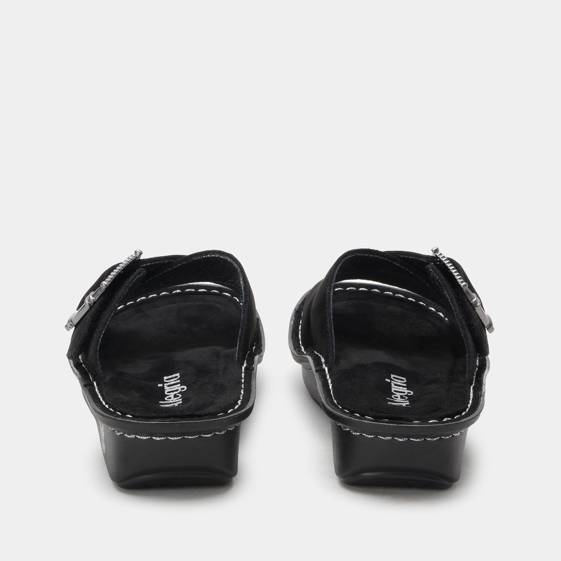 Pair of black sandals with 'Vegano' branding on a light gray background