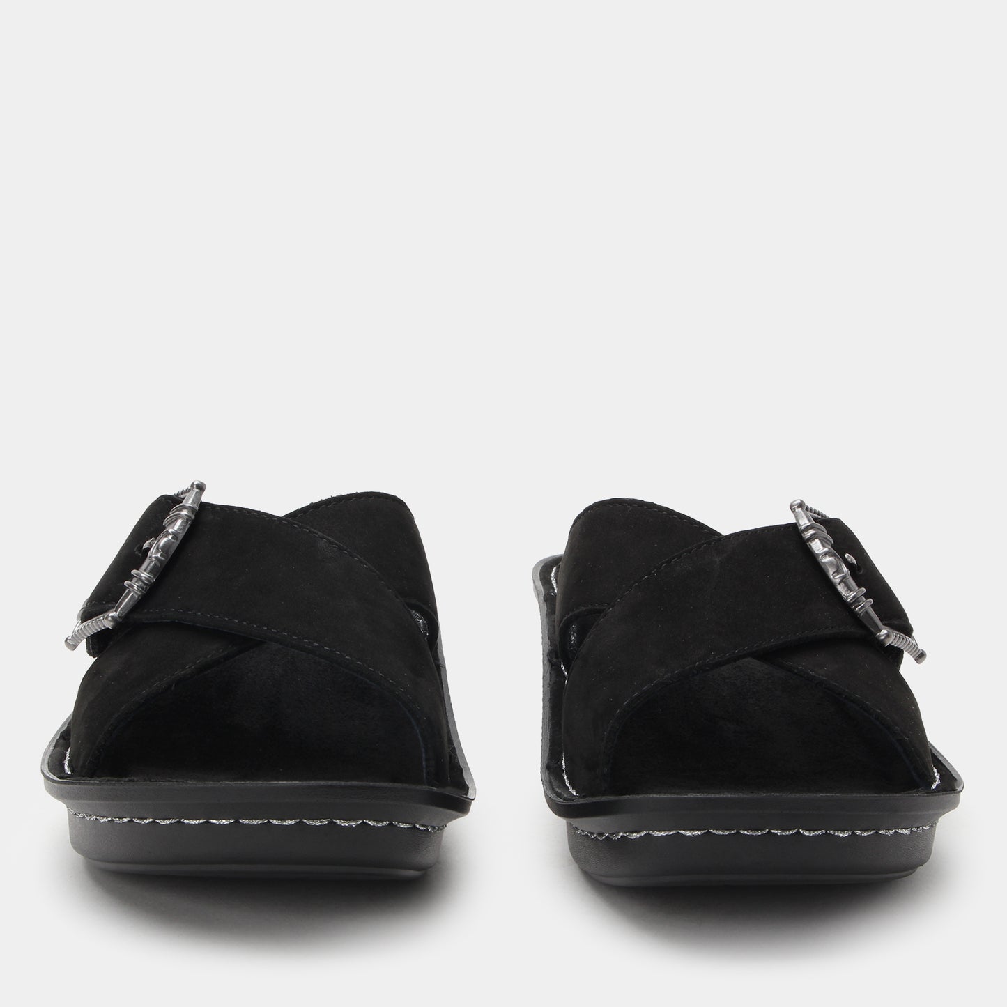 Black sandals with metallic buckles on a white background