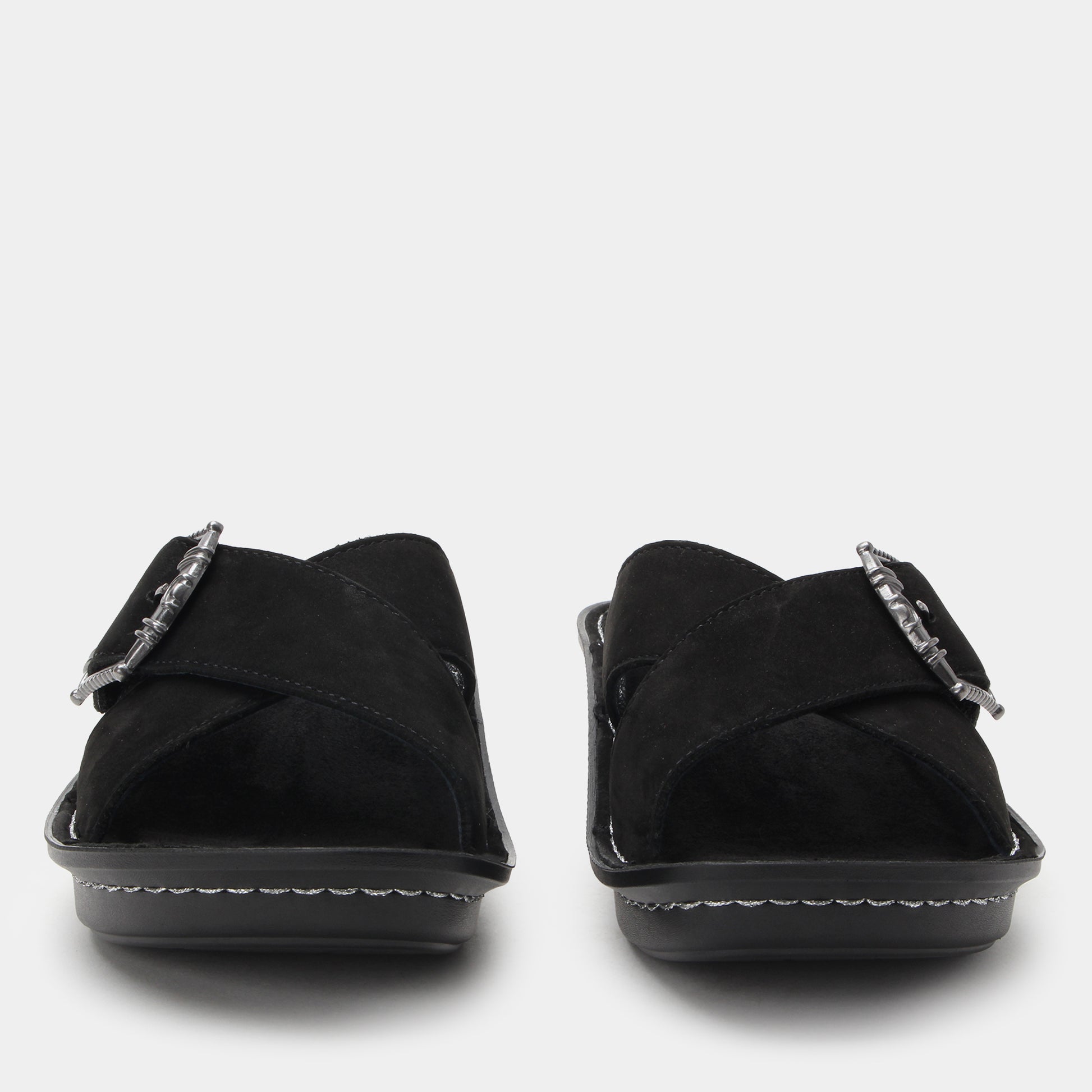 Black sandals with metallic buckles on a white background