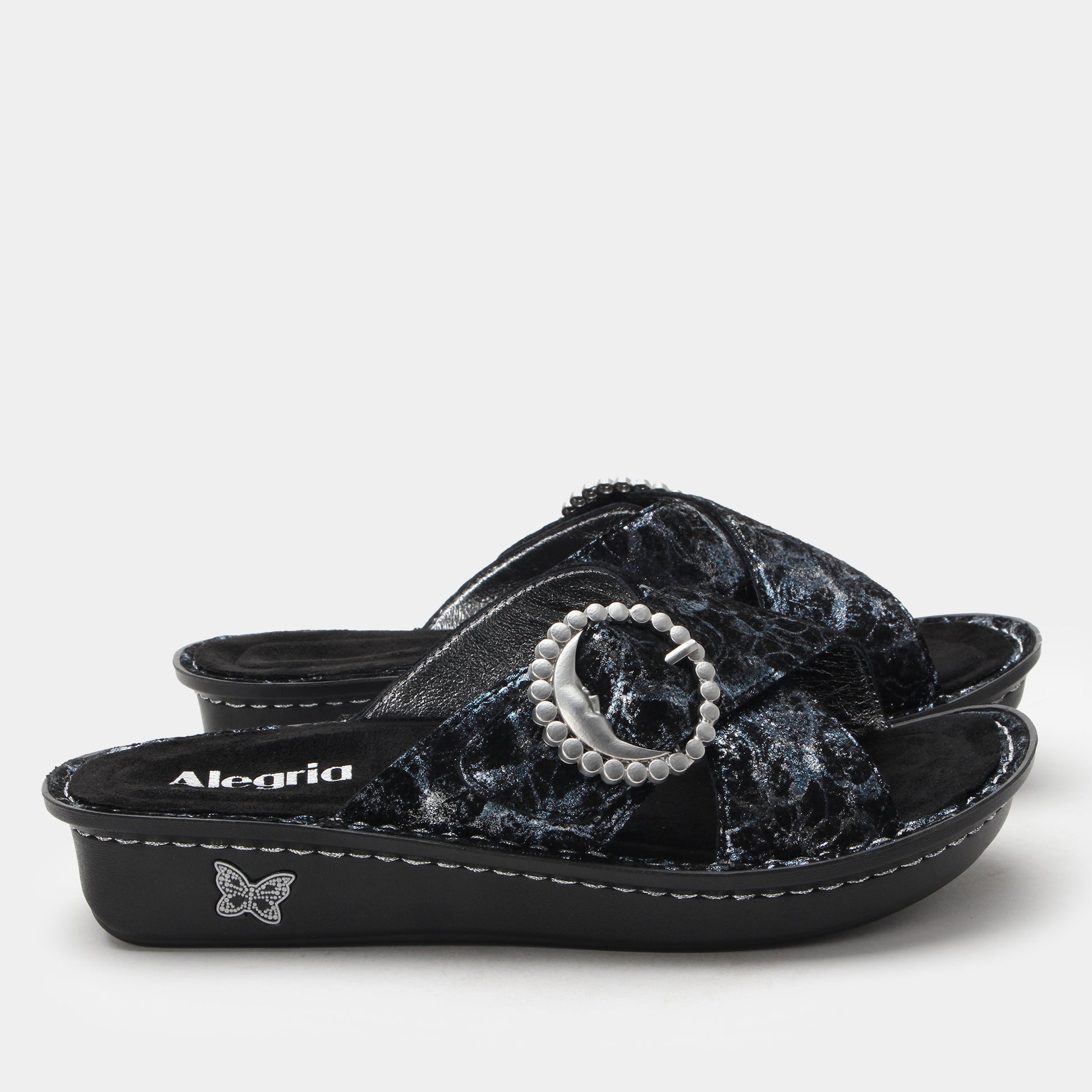 Black sandal with decorative bow and pearl detail on a white background